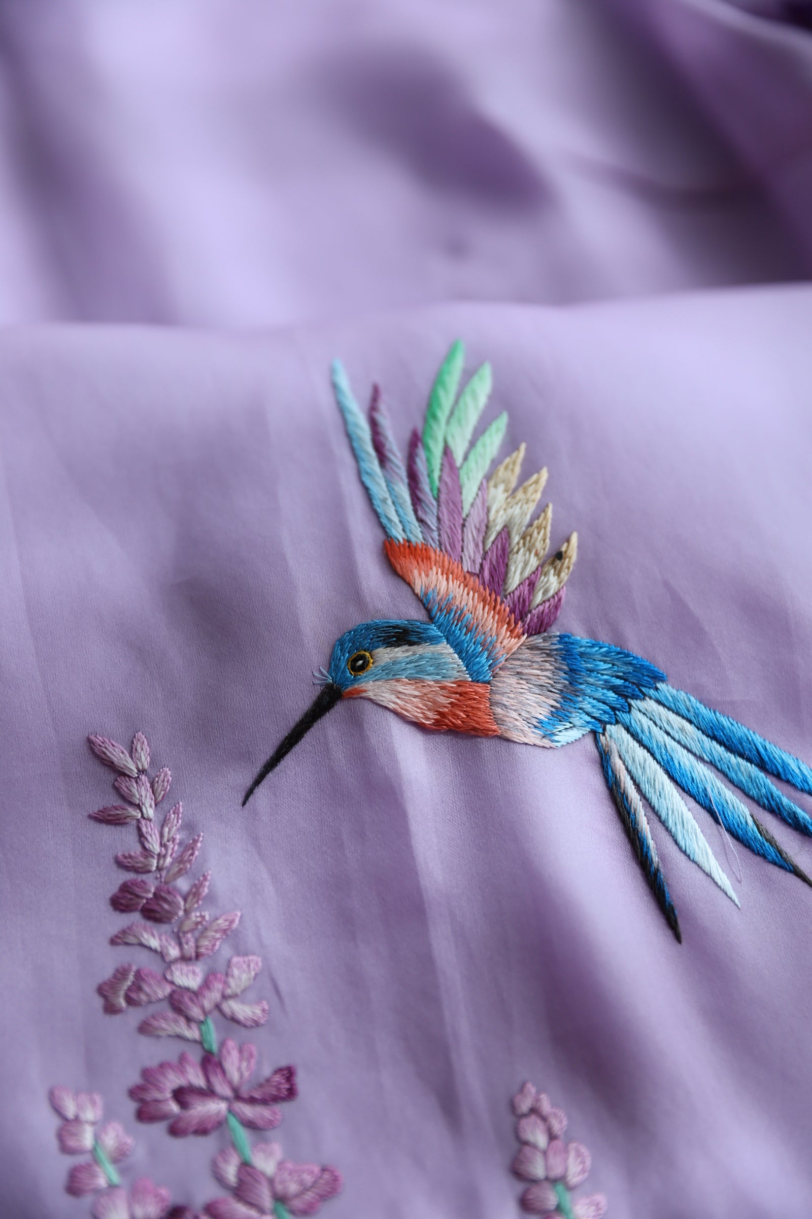 Close-up of the rainbow color wild bird on a lavender silk organza Qipao for mother. 