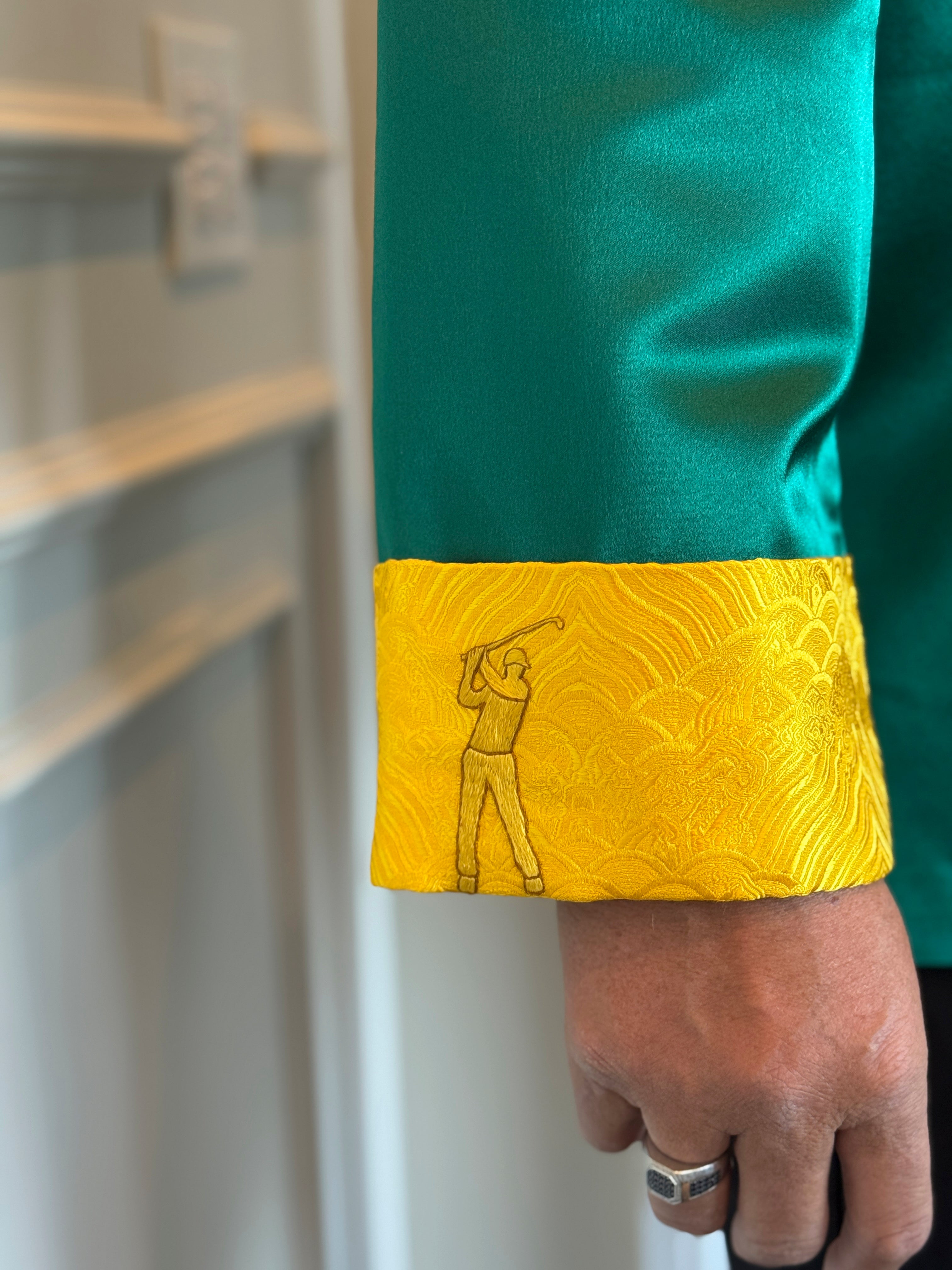 Details of hand embroidery of a professional golfer on the right calf of a green silk tang suit. 