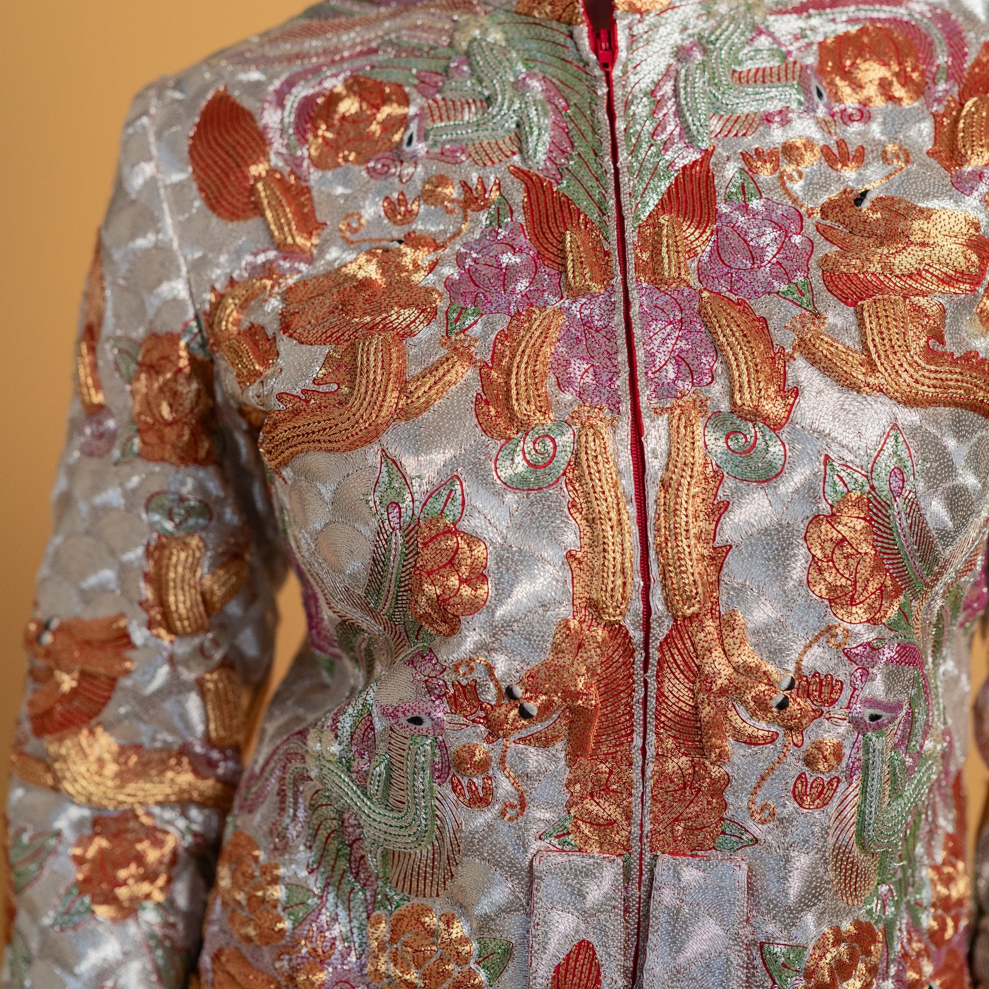 A detailed image of 3-d hand-embroidered Panjin embroidery of a traditional chinese wedding dress King Kwa.