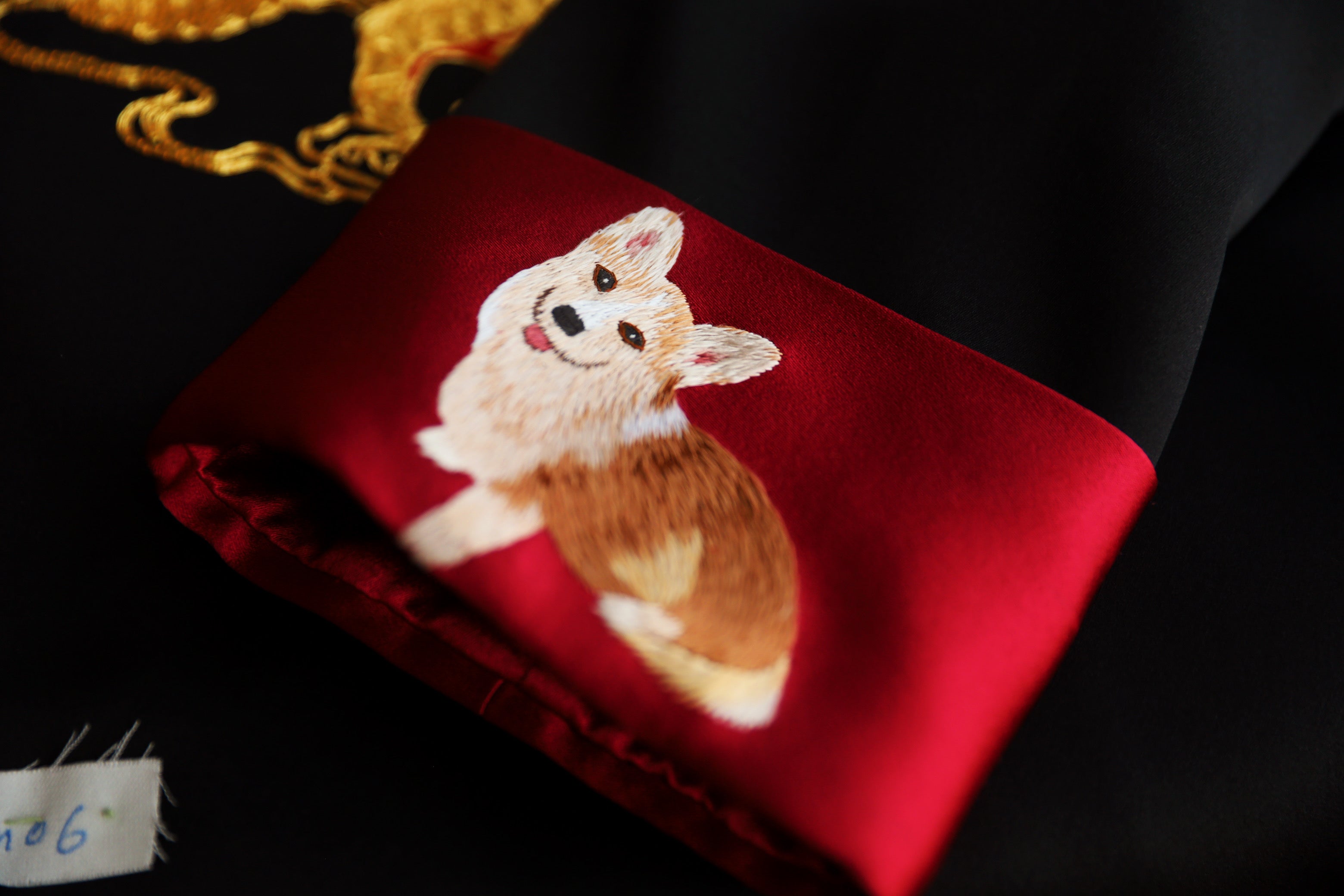 A black silk tang suit for groom with a dog embroidered on the sleeve