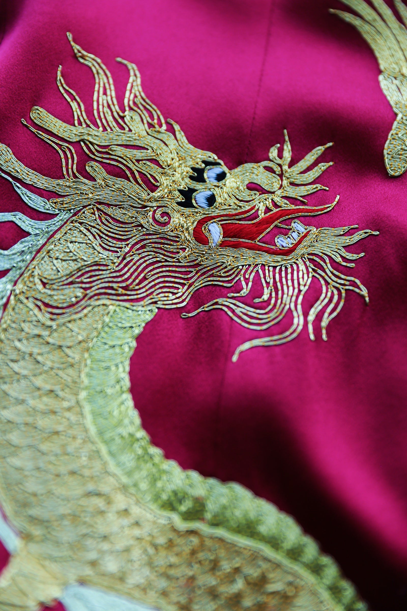 Hand-embroidered dragon detail on red silk Qipao Chinese wedding dress.