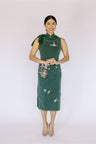 Front view of an emerald green modern Cheongsam Qipao, ideal for a summer night, featuring a sophisticated design with a touch of traditional charm