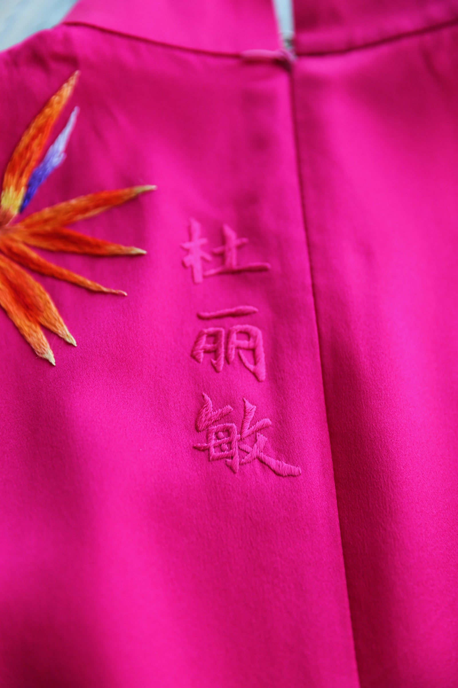 Family name embroidered on a red Qipao