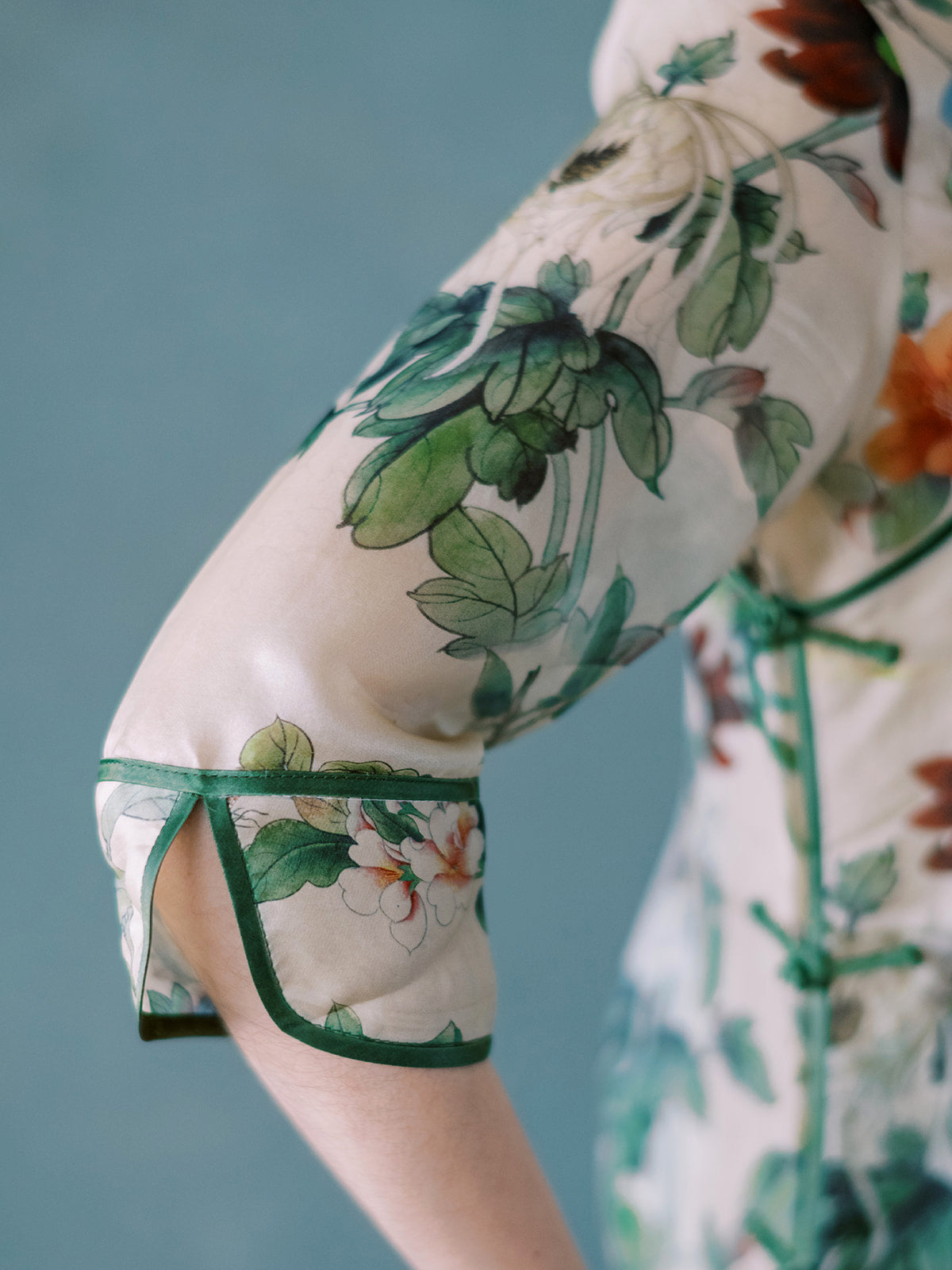Close-up of dark green silk trim and floral embroidery on Shanghai Garden Qipao dress