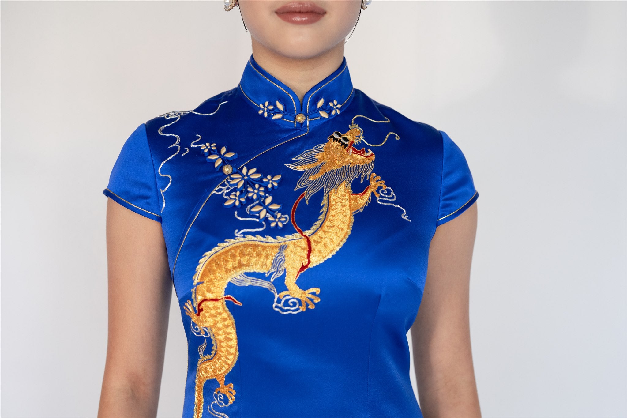 Close-up of gold hand-embroidered dragon on royal blue cheongsam