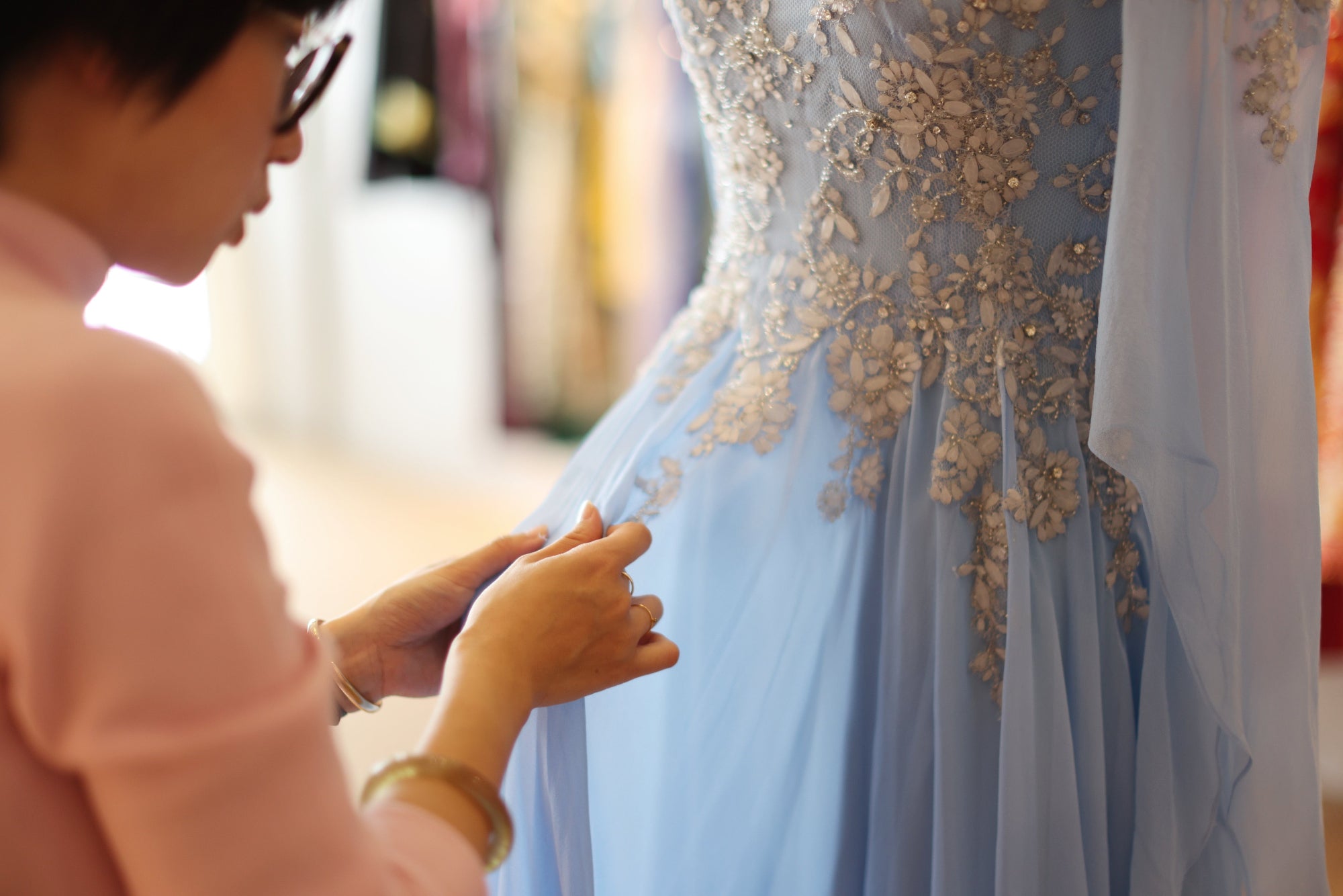Pei sewing a custom Qipao in Los Angeles design studio