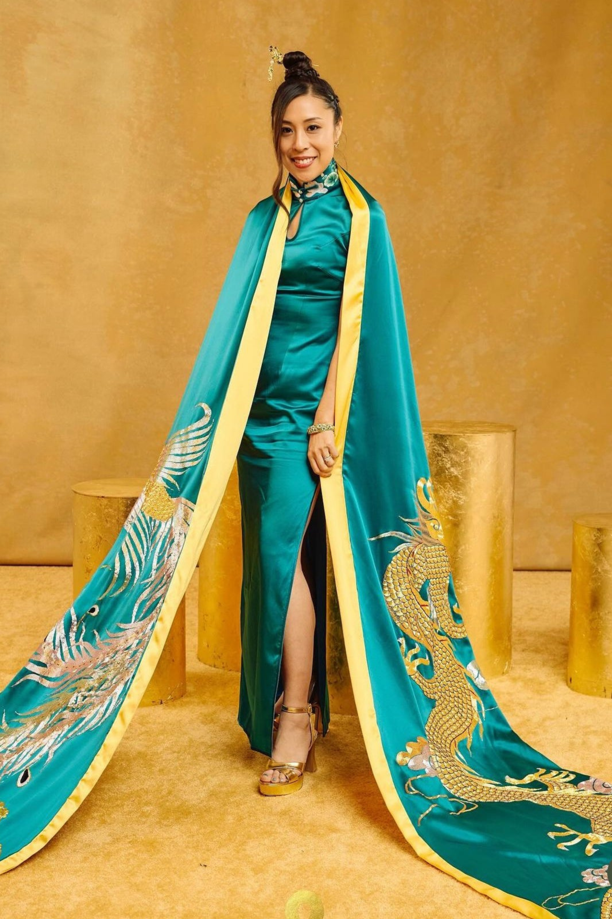 Real client wearing green and gold silk modern Cheongsam with detachable cape, hand-embroidered dragon and phoenix by JINZA Oriental Couture