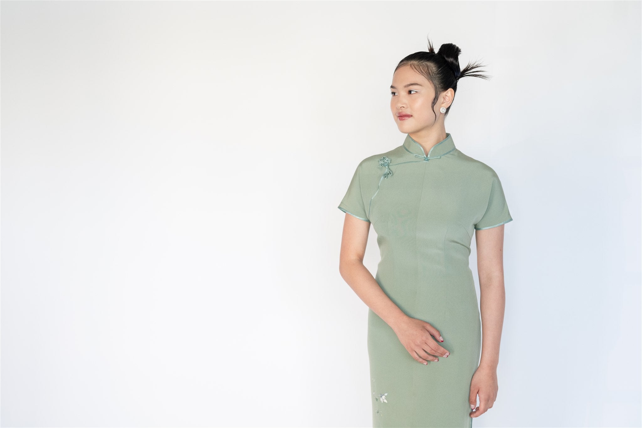Close-up of Japanese silk fabric on green cheongsam, lightweight and breathable texture
