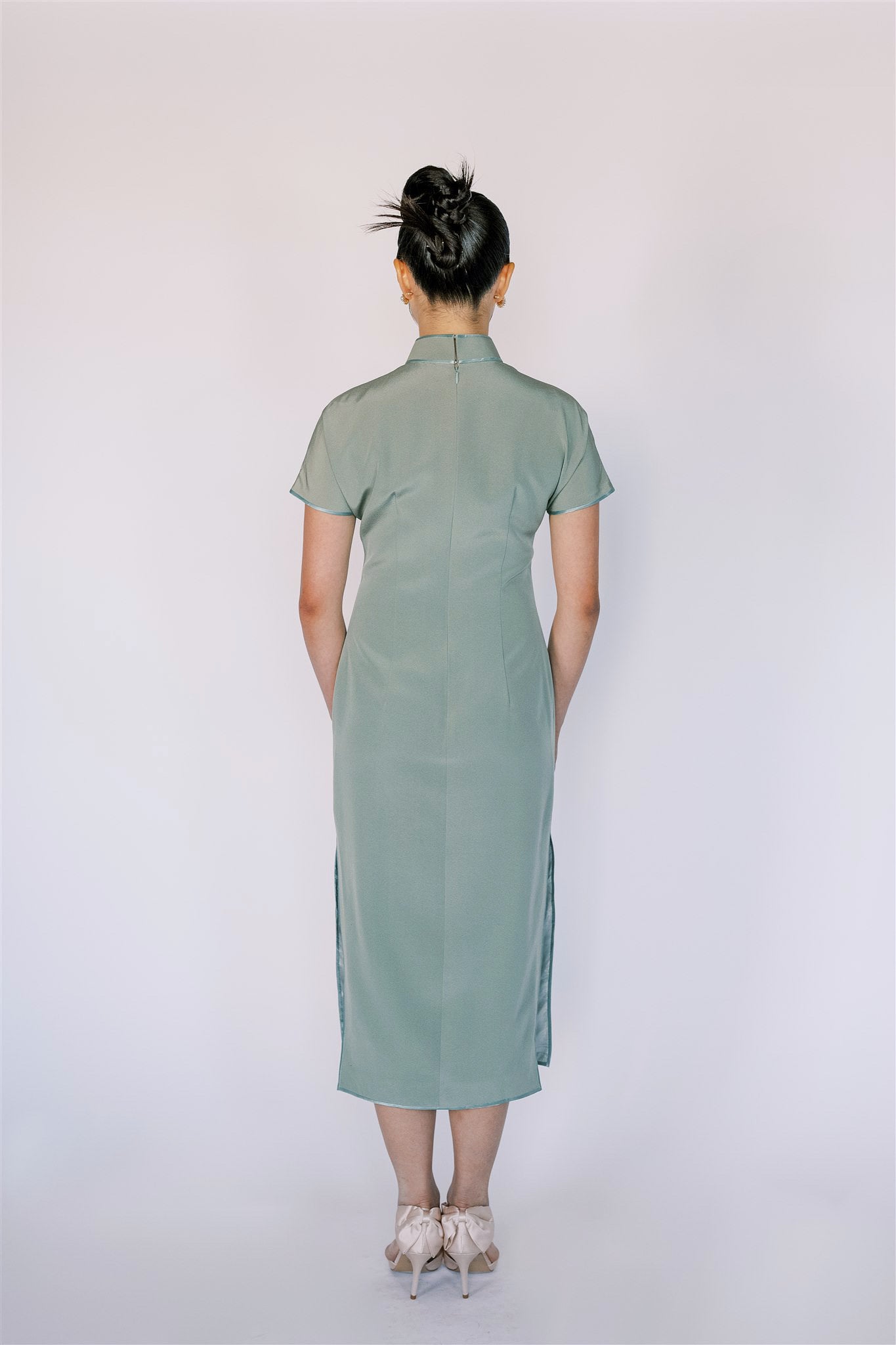 A girl wearing a green Japanese silk Cheongsam with mid-calf length and mandarin collar