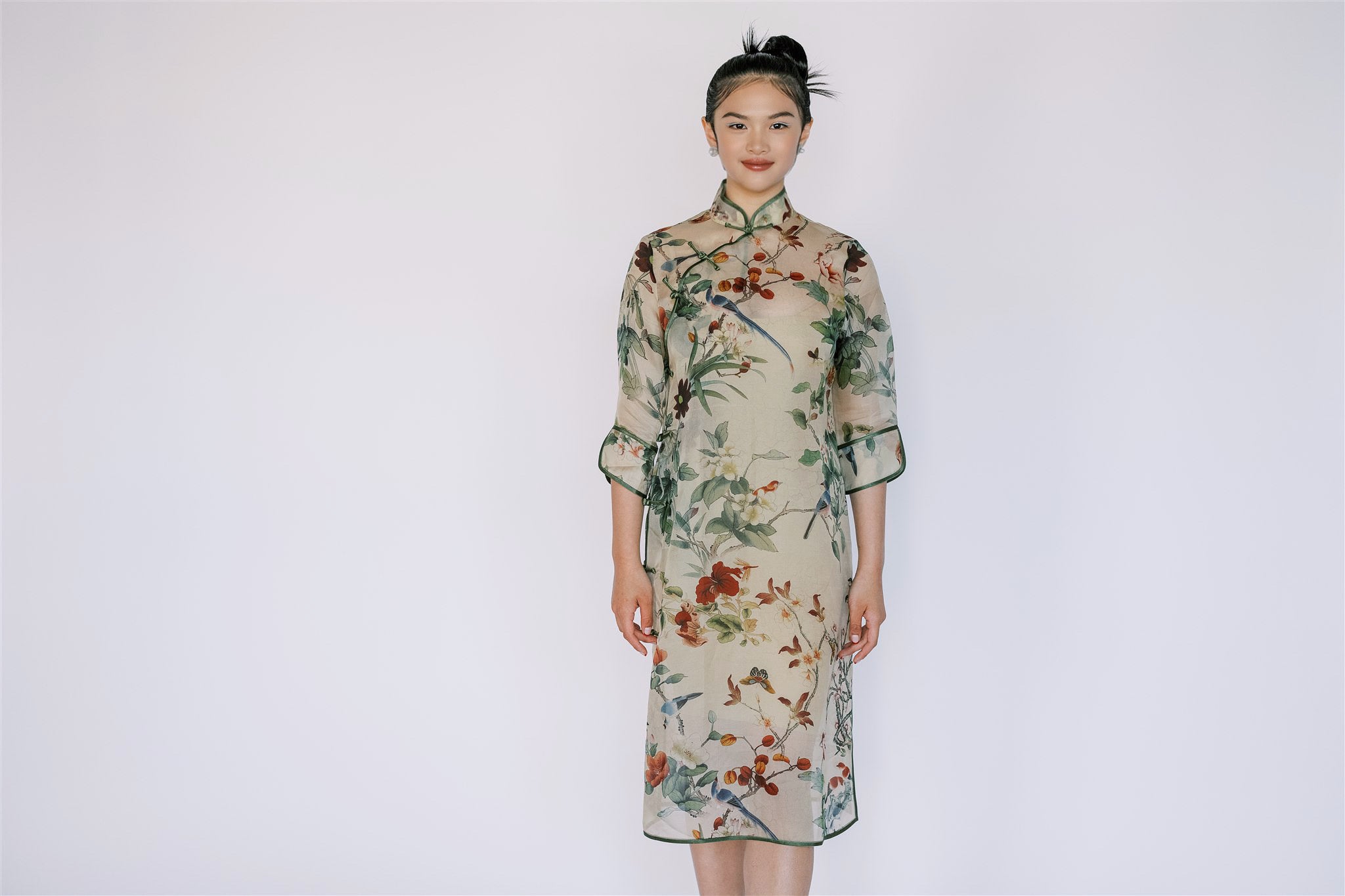 A girl wearing green A-line Cheongsam, mid-calf length, 3/4 sleeves.