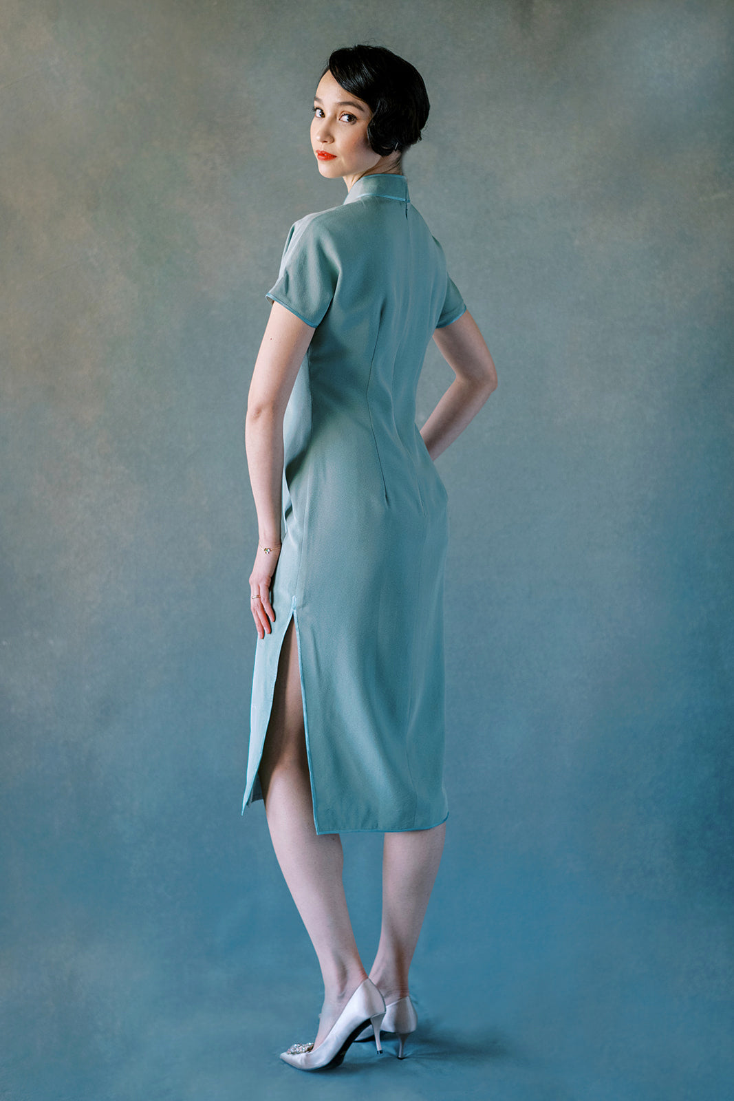 Back view of green silk Cheongsam dress with orchid embroidery and dark green trim.