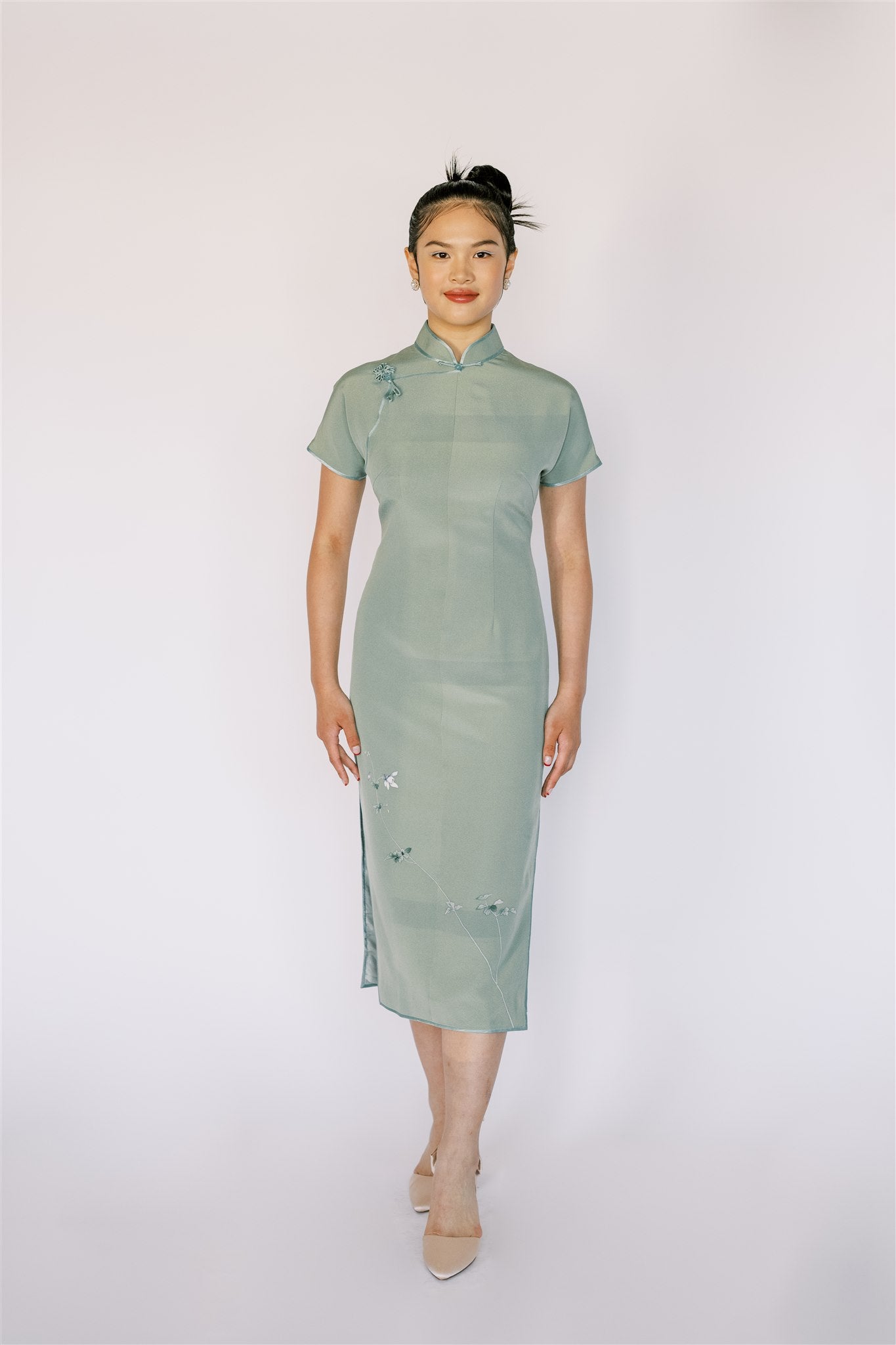 A girl wearing a green Japanese silk Qipao mid-calf length