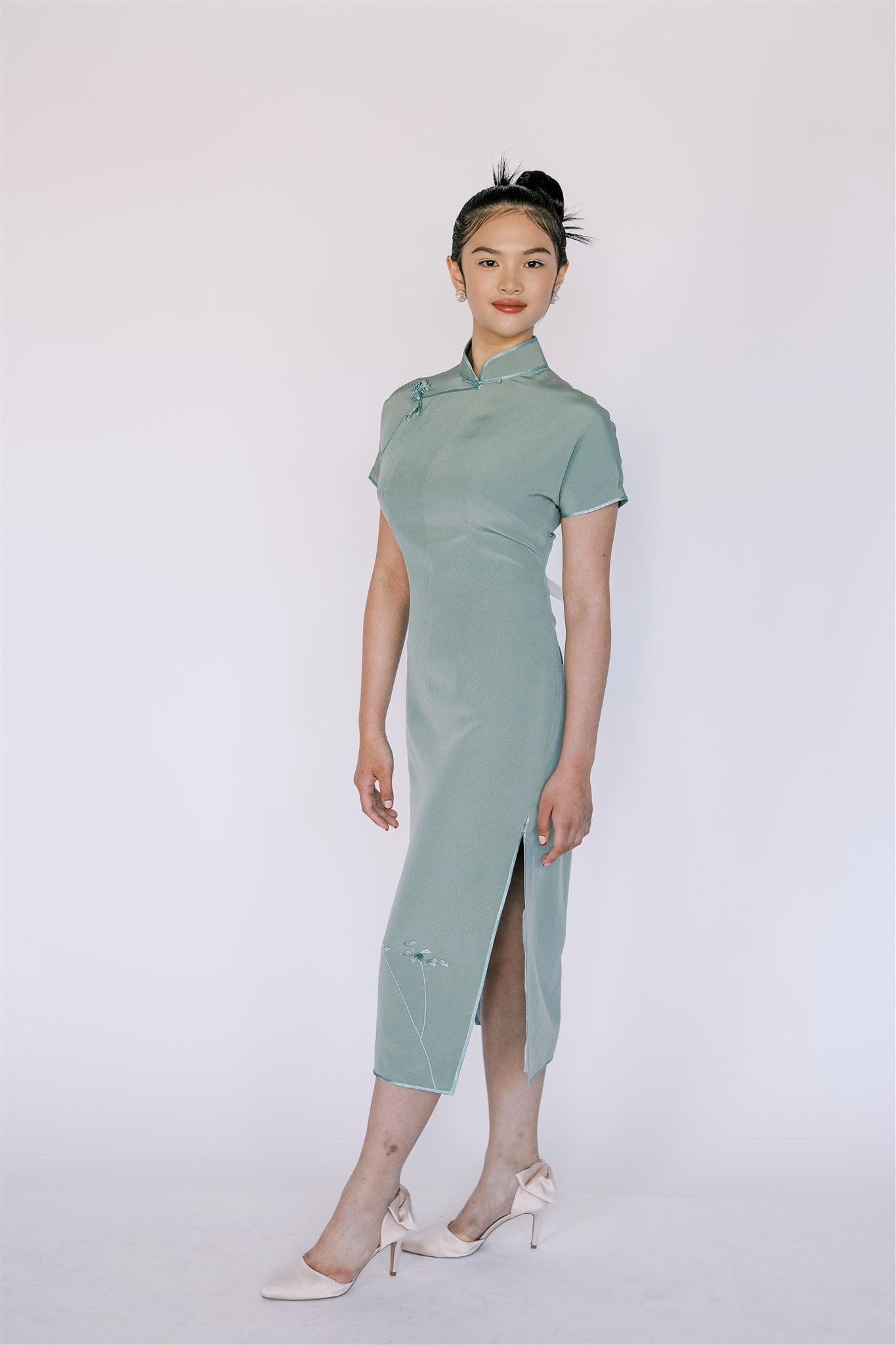 Qipao in Japanese green silk, featuring traditional Pankou knot and mandarin collar. 