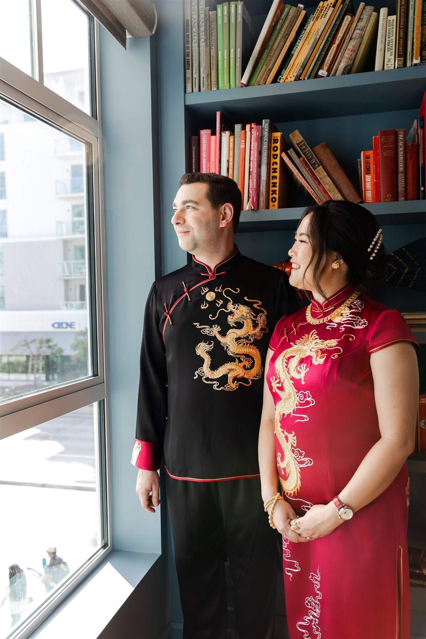 Side view of a groom dressed in a black Tang suit with gold dragon embroidery and matching pants, perfect for a wedding.