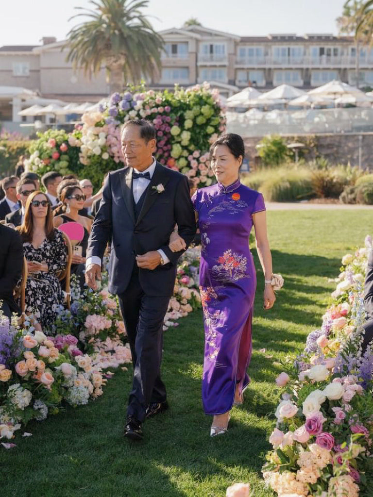 Hand-embroidered mountains, rivers, and trees on a silk Cheongsam, symbolizing grace and strength for mothers at weddings. 