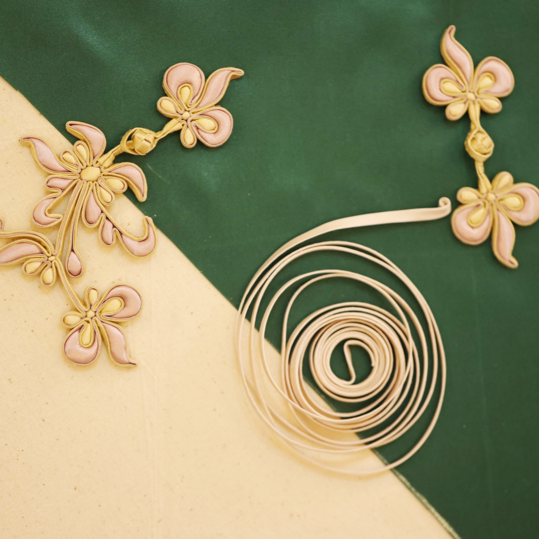 Final embroidery and hand-sewn trim on a silk Cheongsam by JINZA artisan