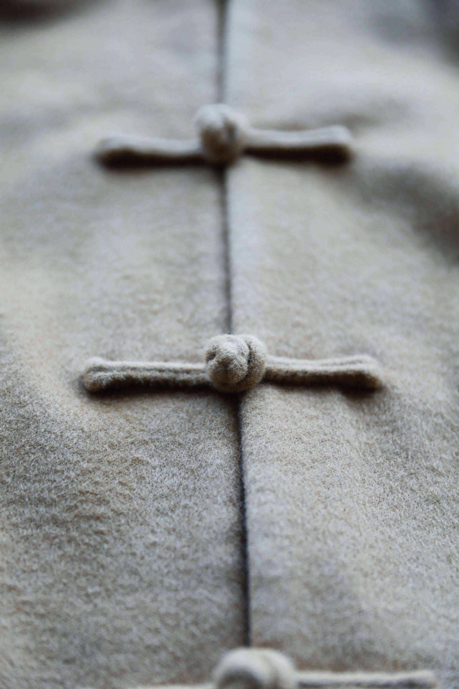 Close-up of premium Italian wool Tang suit featuring a hand-shaped mandarin collar and traditional handmade pankou knot closure.