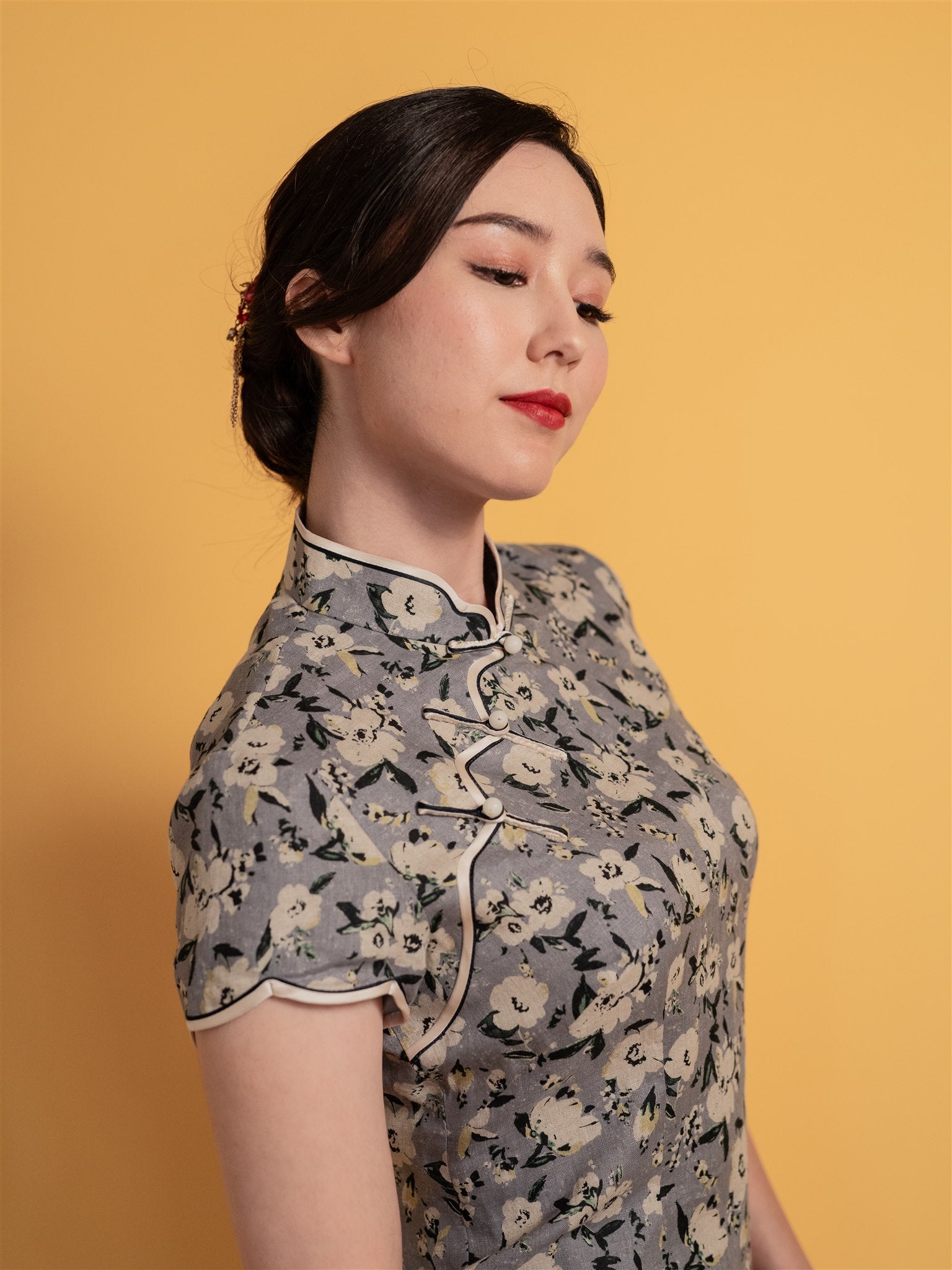 Close-up detail of the floral neckline and trims on a grey floral Japanese cotton Qipao, designed for a stylish and youthful graduation celebration.