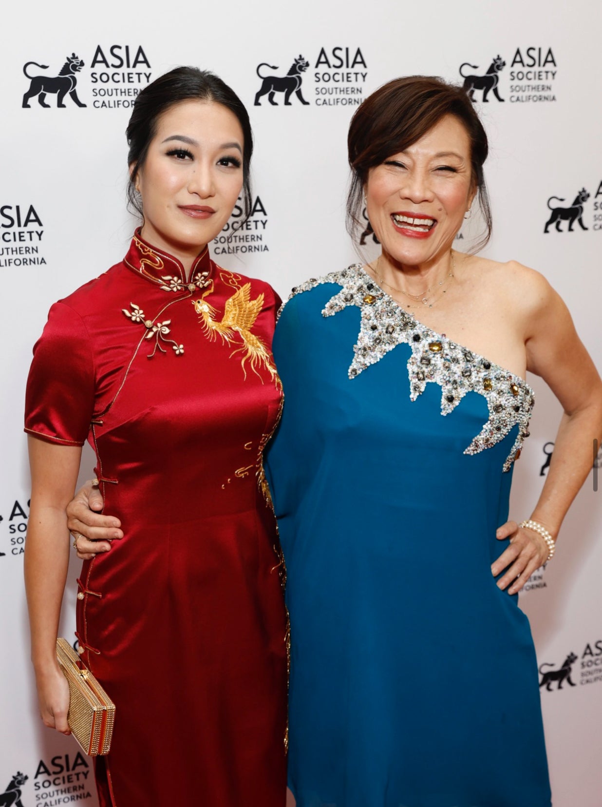 Actress Kara Wang wearing a red silk phoenix Qipao by JINZA Oriental Couture with Oscar President Janet Yang at the Asia Society Gala in Los Angeles.
