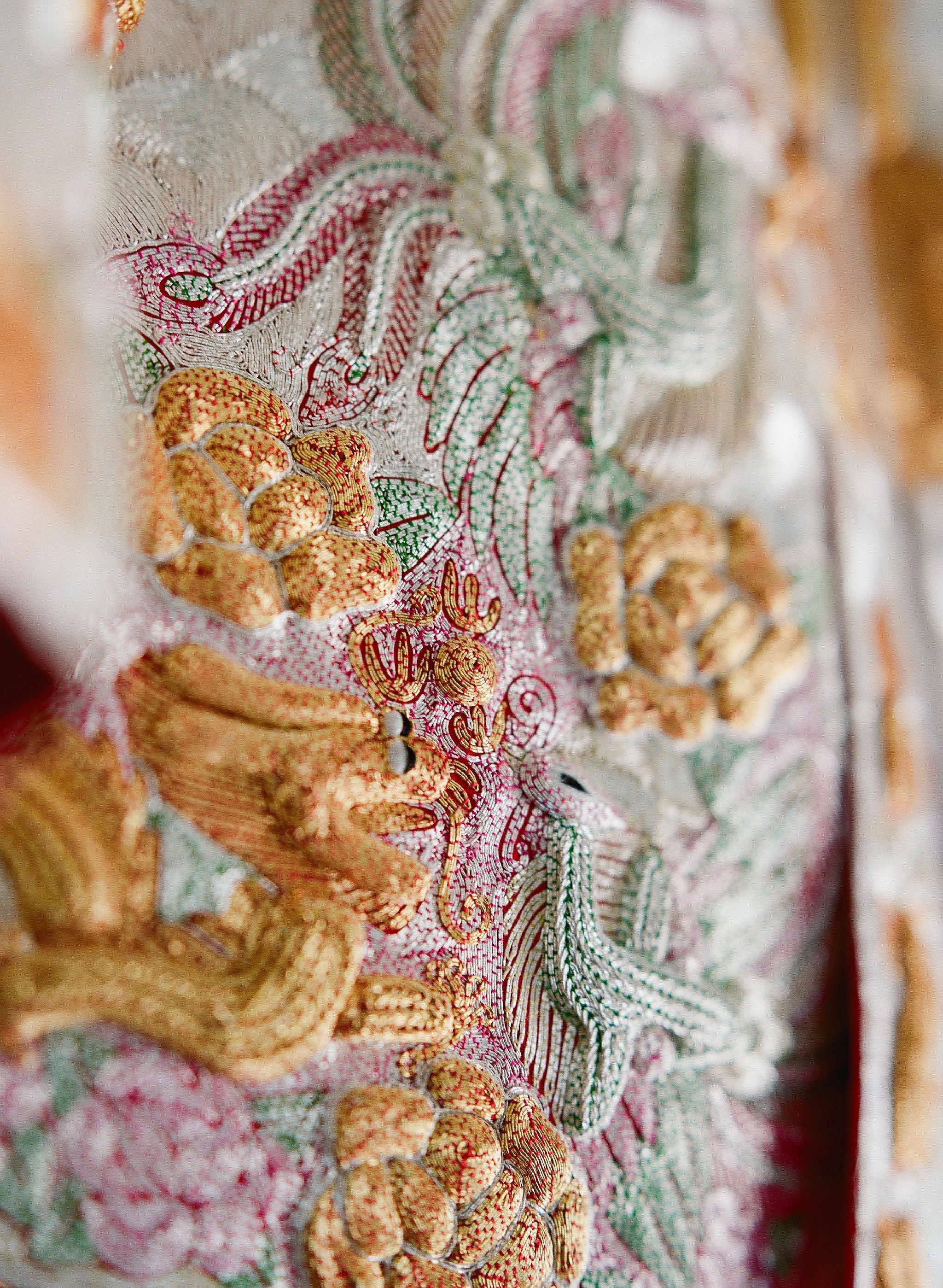 Close-up of details of 3D dragon, phoenix and peony embroidery details on Traditional Chinese Wedding Dress Qun Kwa.