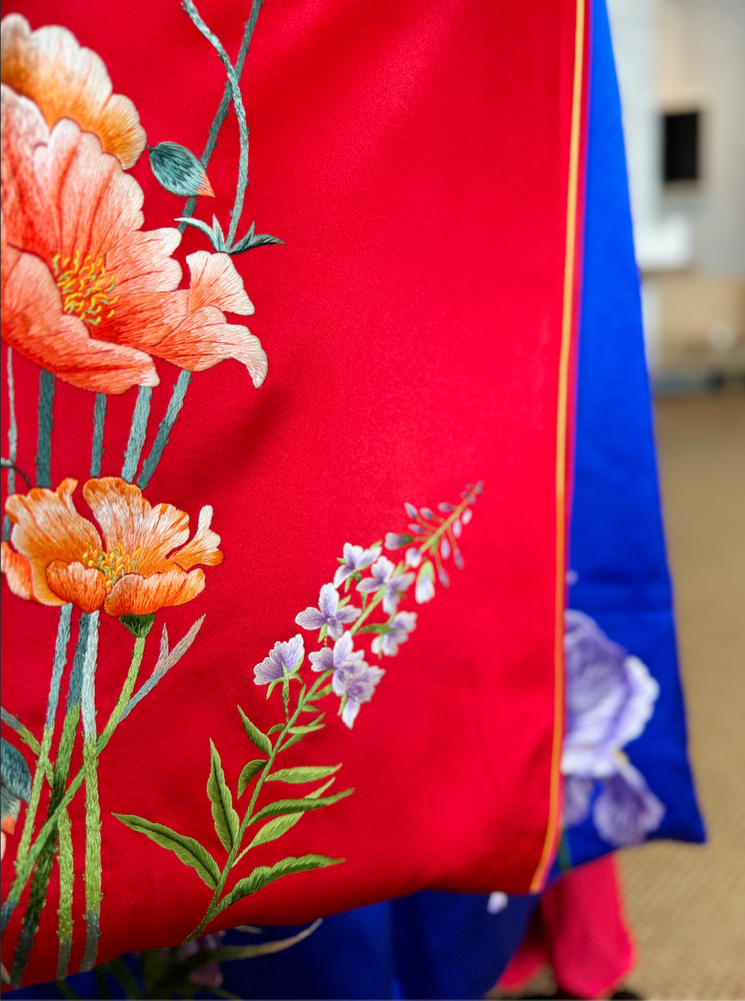 detailed image of hand-embroidered lavender flower on the red Qipao wedding dress. 