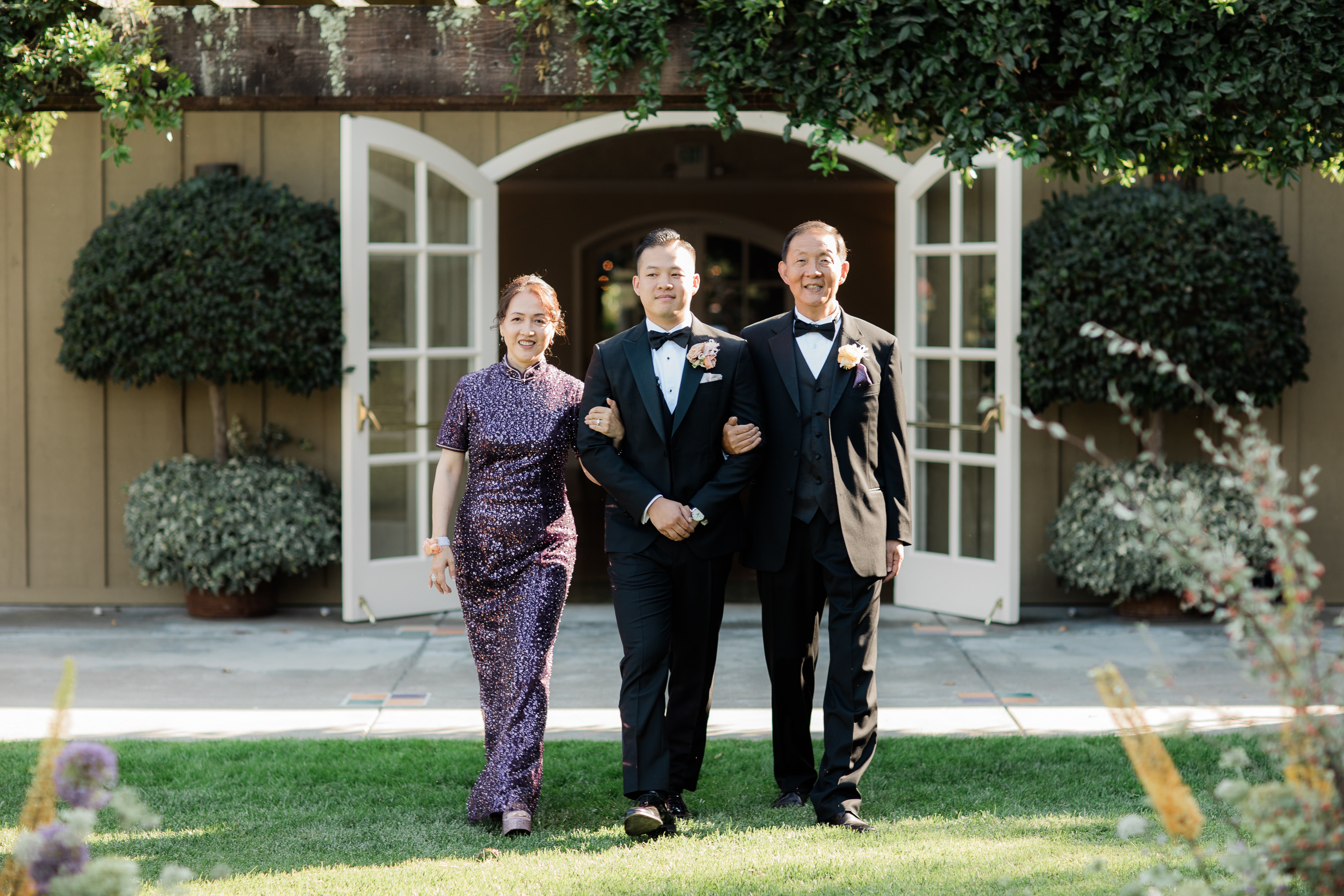 A mother wearing a dark purple sequenced beading silk Qipao at her son's wedding