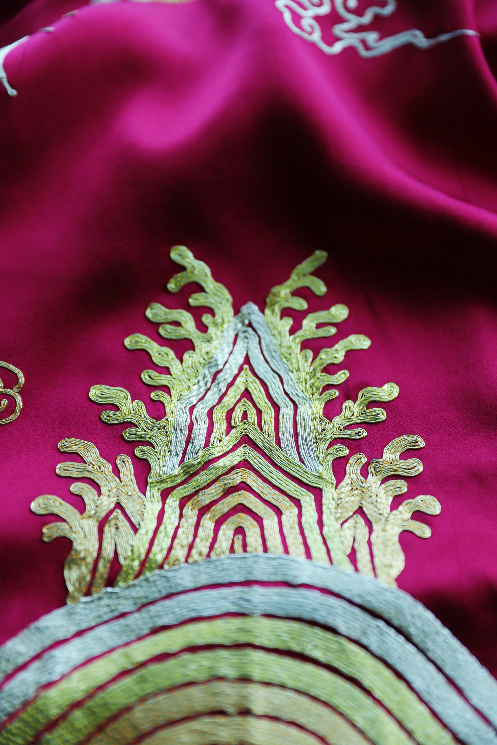 Lucky sea-wave embroidery detail on the fully embroidered train of red silk Qipao.