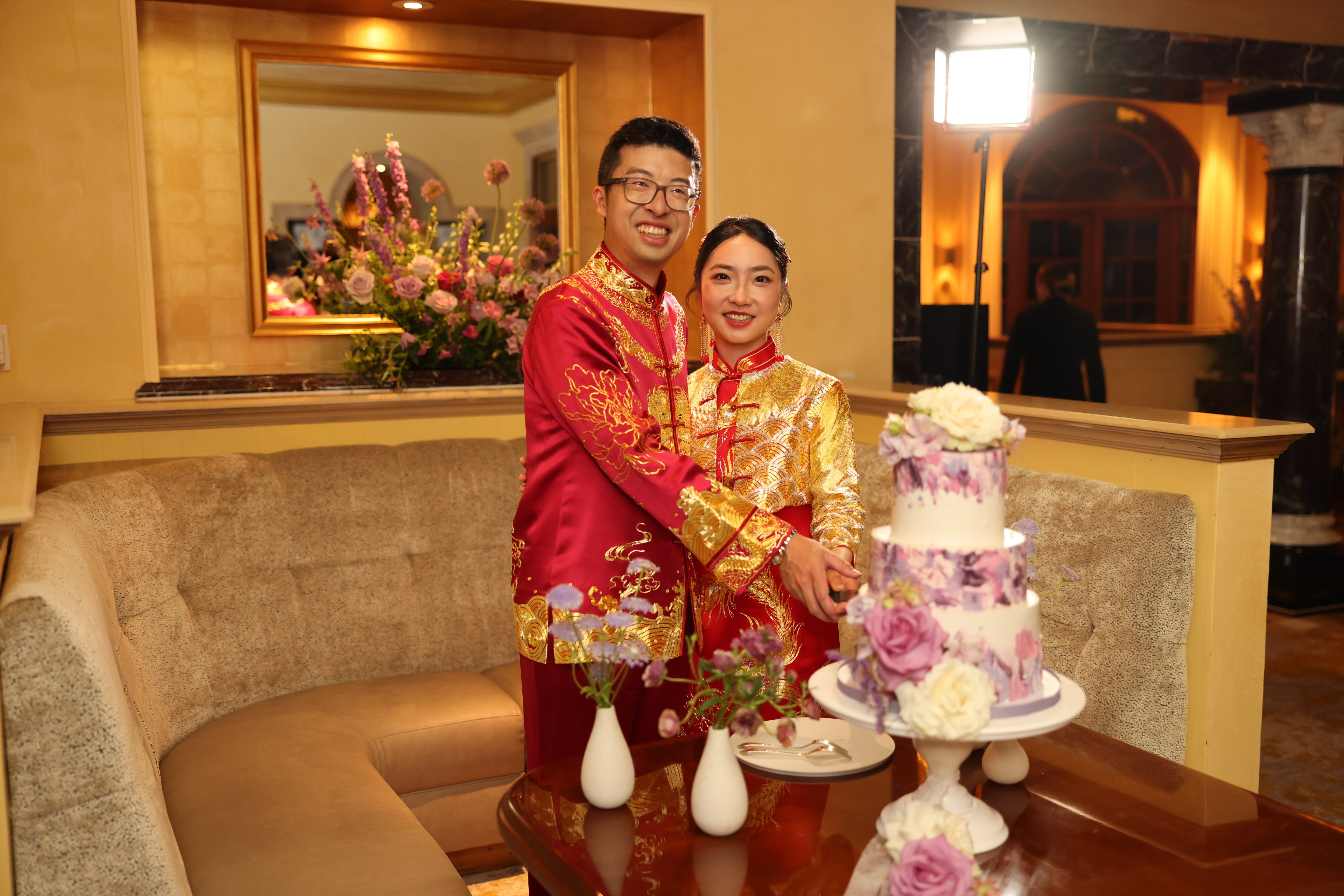 Close up of a groom wearing a luxurious red silk tang suit with 9 dragons embroidery, lucky cloud and sea wave, along with matching silk pants at his tea ceremony 