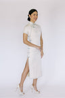 A side view of side slit detail on white Cheongsam dress, it is for enhancing mobility and style.