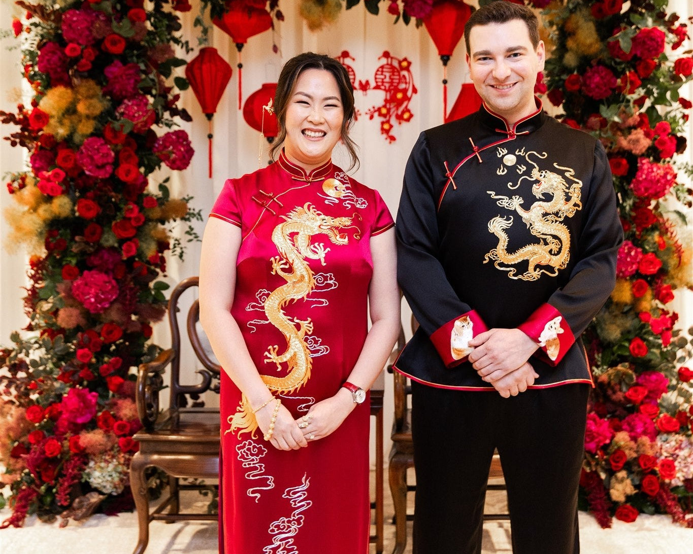 Bride wearing a wine red Qipao with gold embroidery and groom in a black Tang suit, representing the balance of tradition and modern elegance in a Chinese wedding.