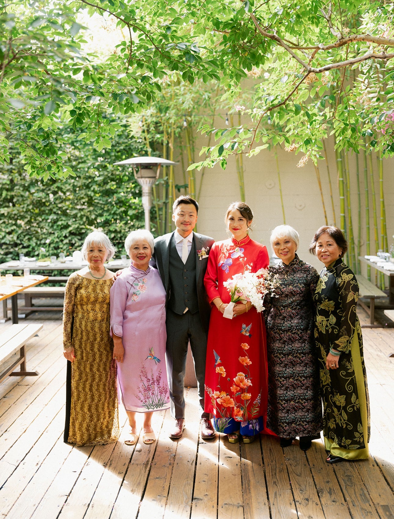 A bride wearing red silk Ao Dai for wedding with her family. 