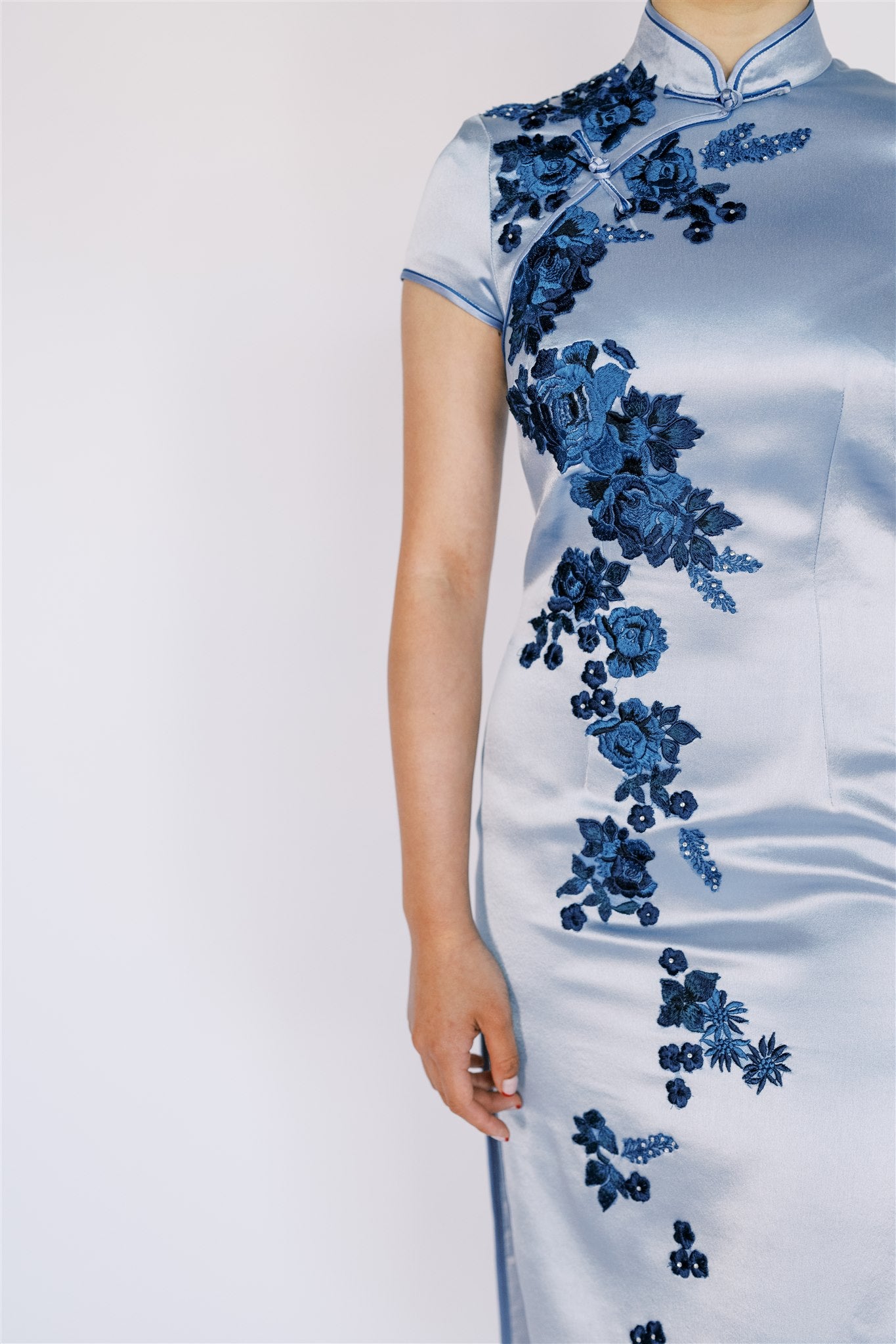 A women wearing light blue modern qipao with velvet floral applique