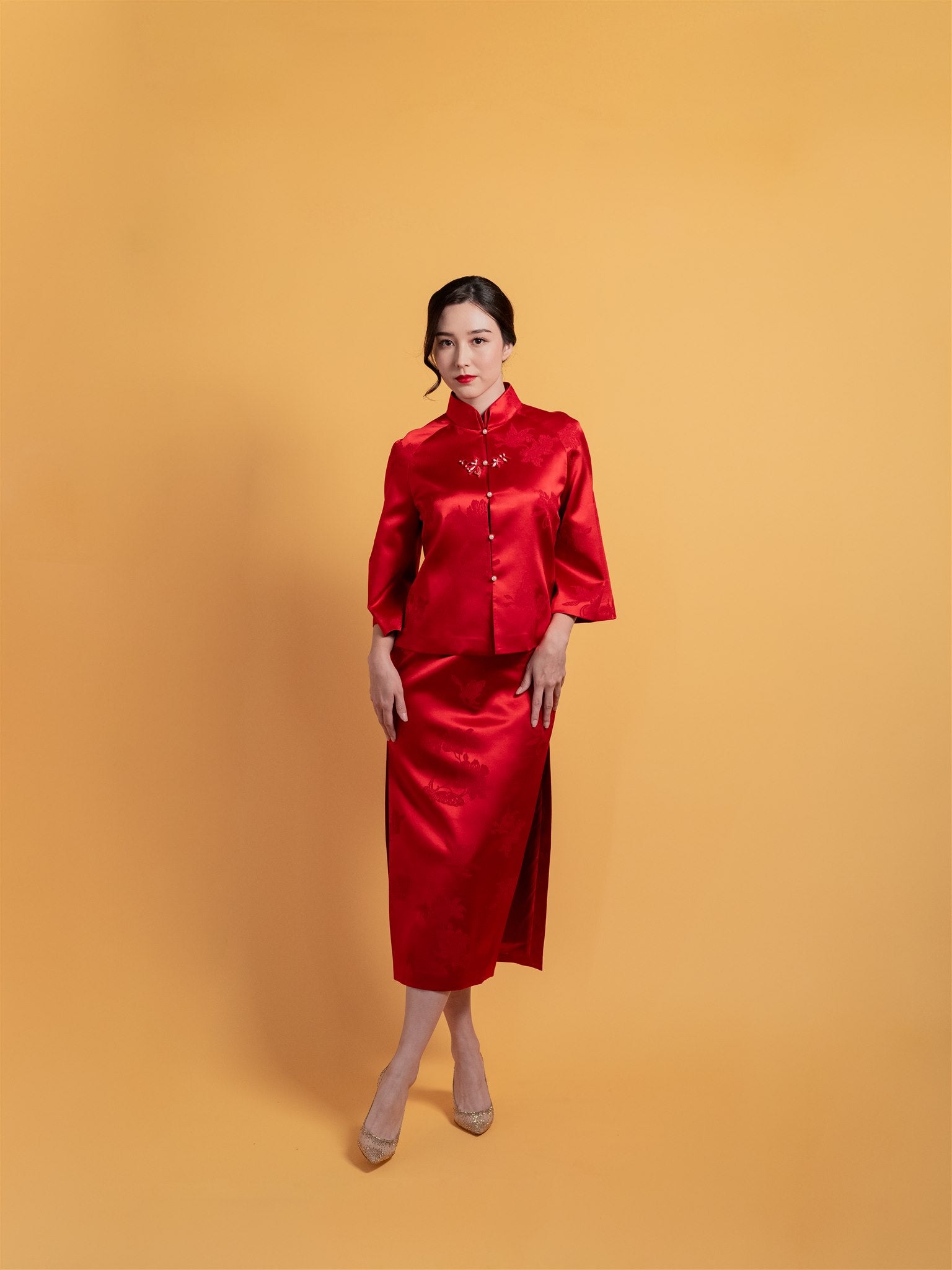 Front view of a short jacket detail with a fitted red Qipao, a modern Cheongsam set offering modest coverage and elegance. 