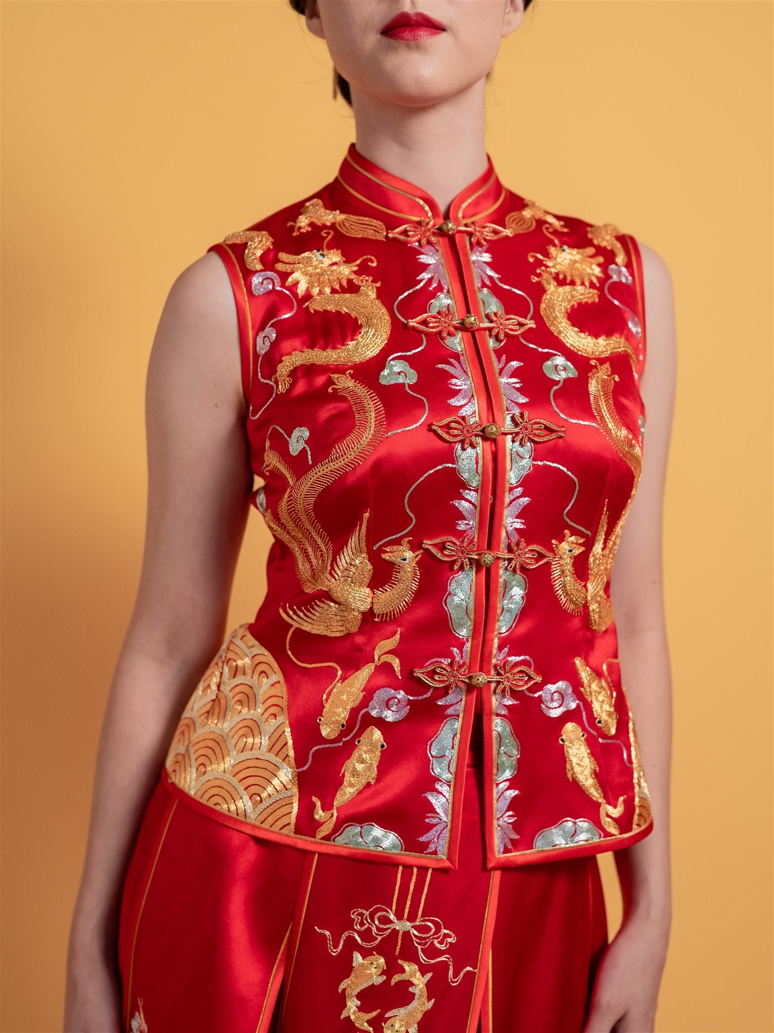 Close-up detail of the fitted top and gold embroidery on the sleeveless modern Xiu He Fu wedding dress with an 8-panel A-line skirt.