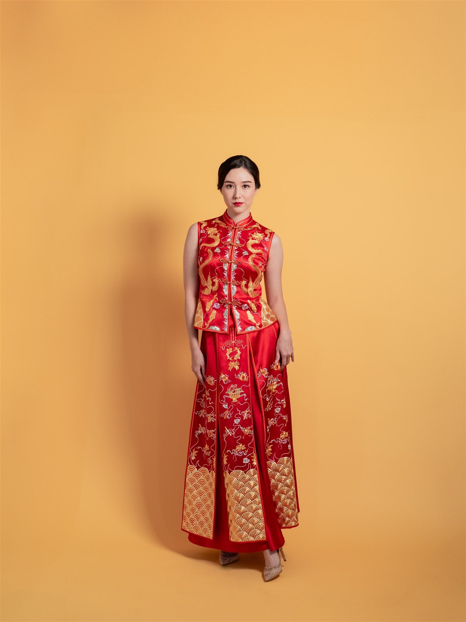 Front view of modern Chinese wedding dress Xiu He Fu with a sleeveless design, fitted top, and an 8-panel A-line skirt.