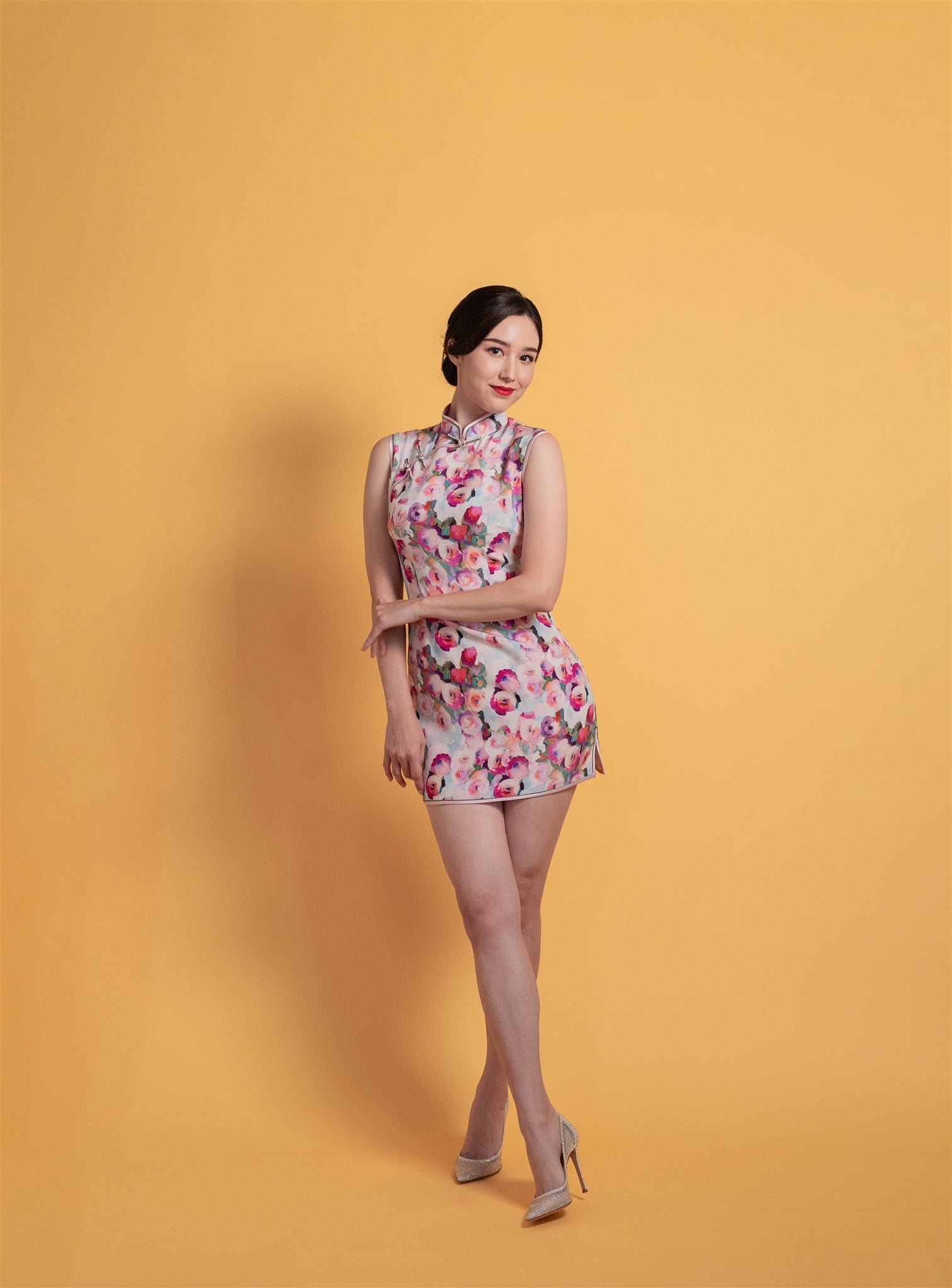 Front view of a modern short pink silk floral Cheongsam, over-the-knee length, sleeveless, perfect for a fun party or daily look.