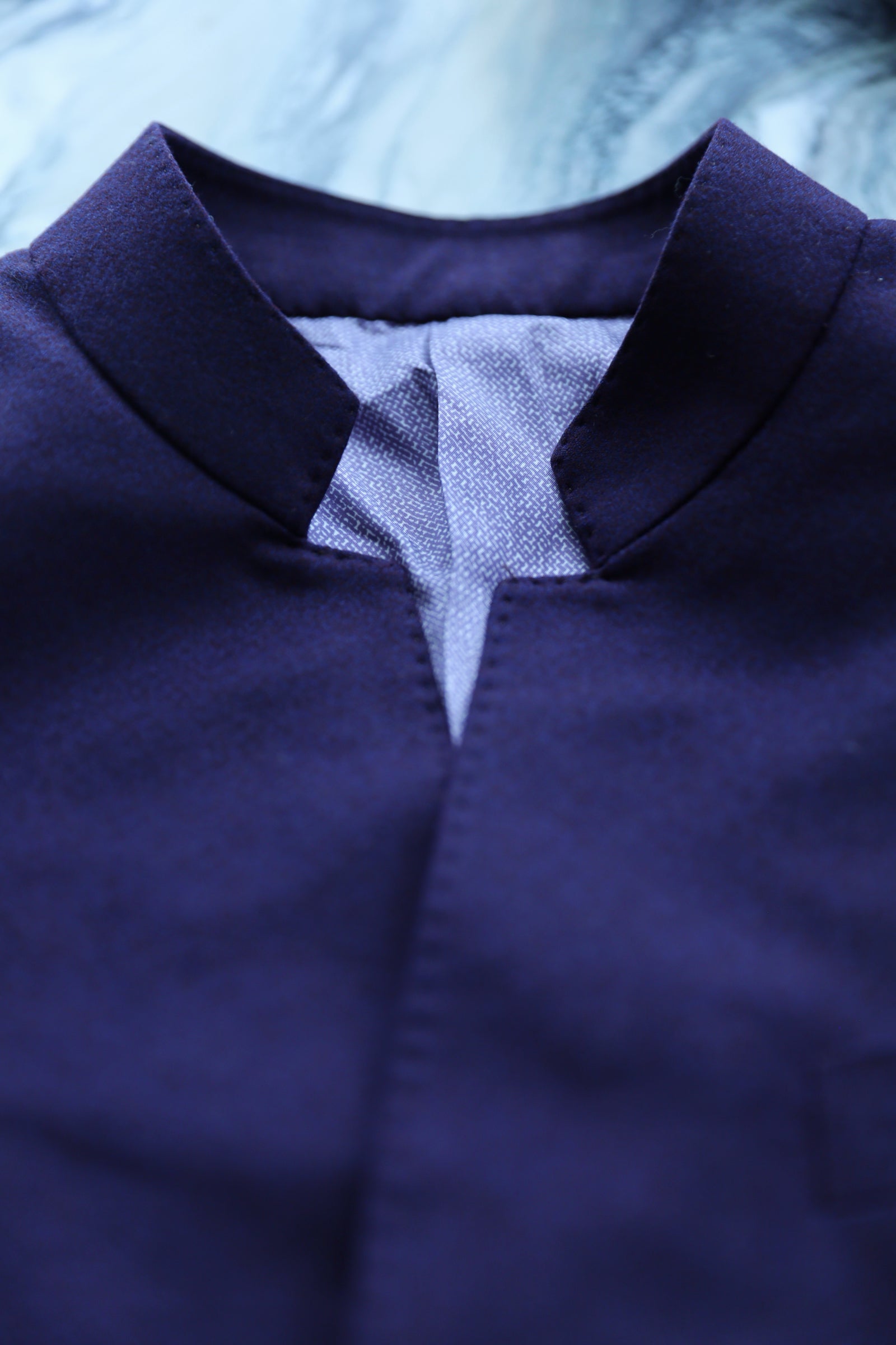 Close-up of open neckline and hand-finished collar on modern Zhongshan suit.