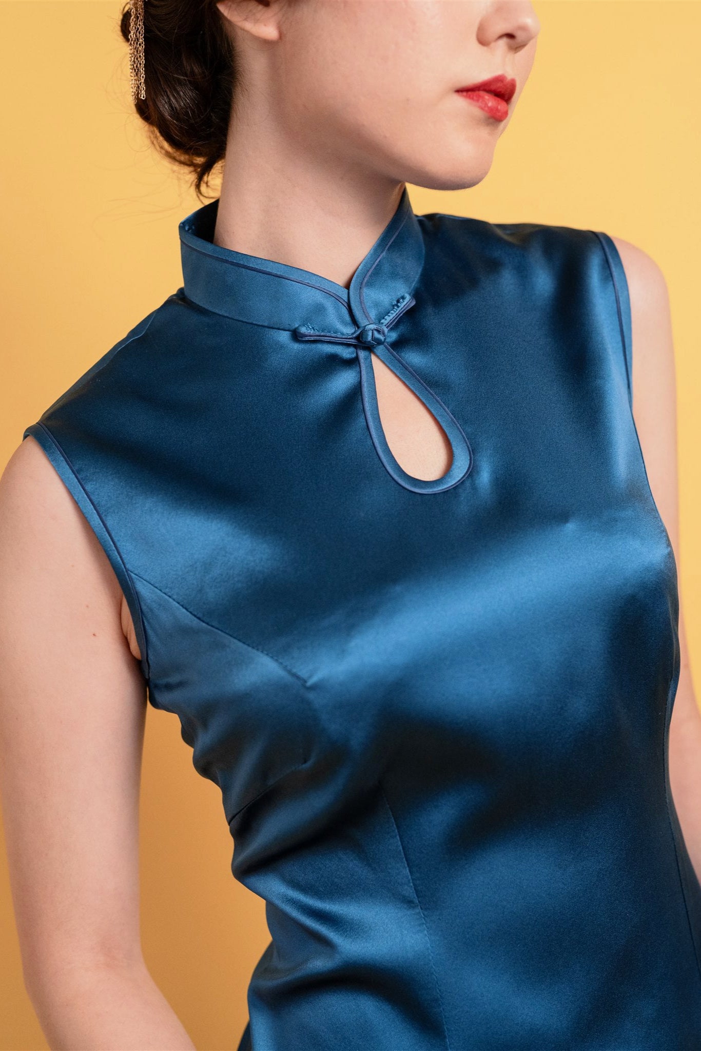 Detail of waterdrop neckline and dark navy trim on silk Cheongsam.