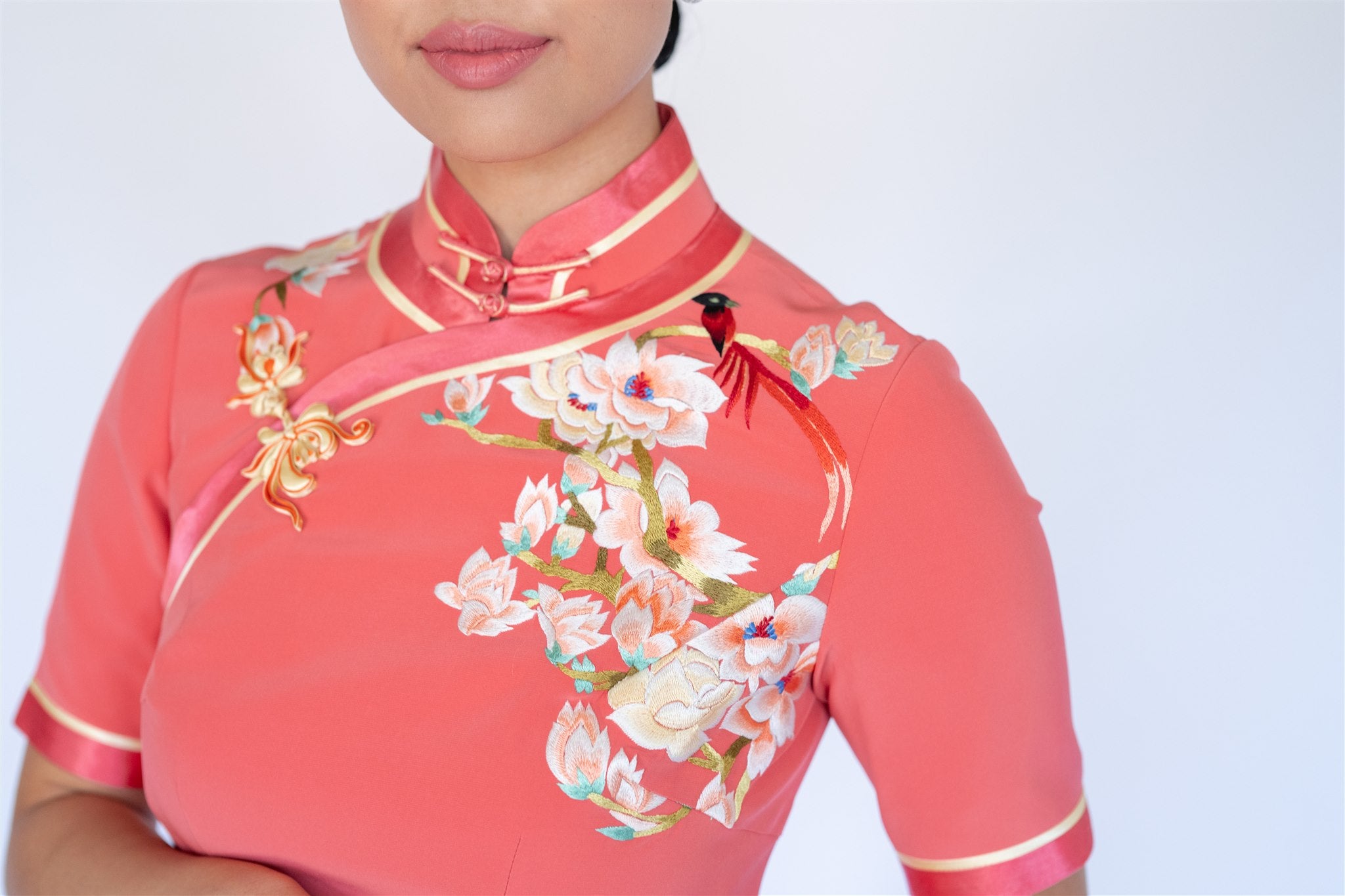 Close-up of cherry blossom embroidery on silk Cheongsam with yellow piping and floral motif