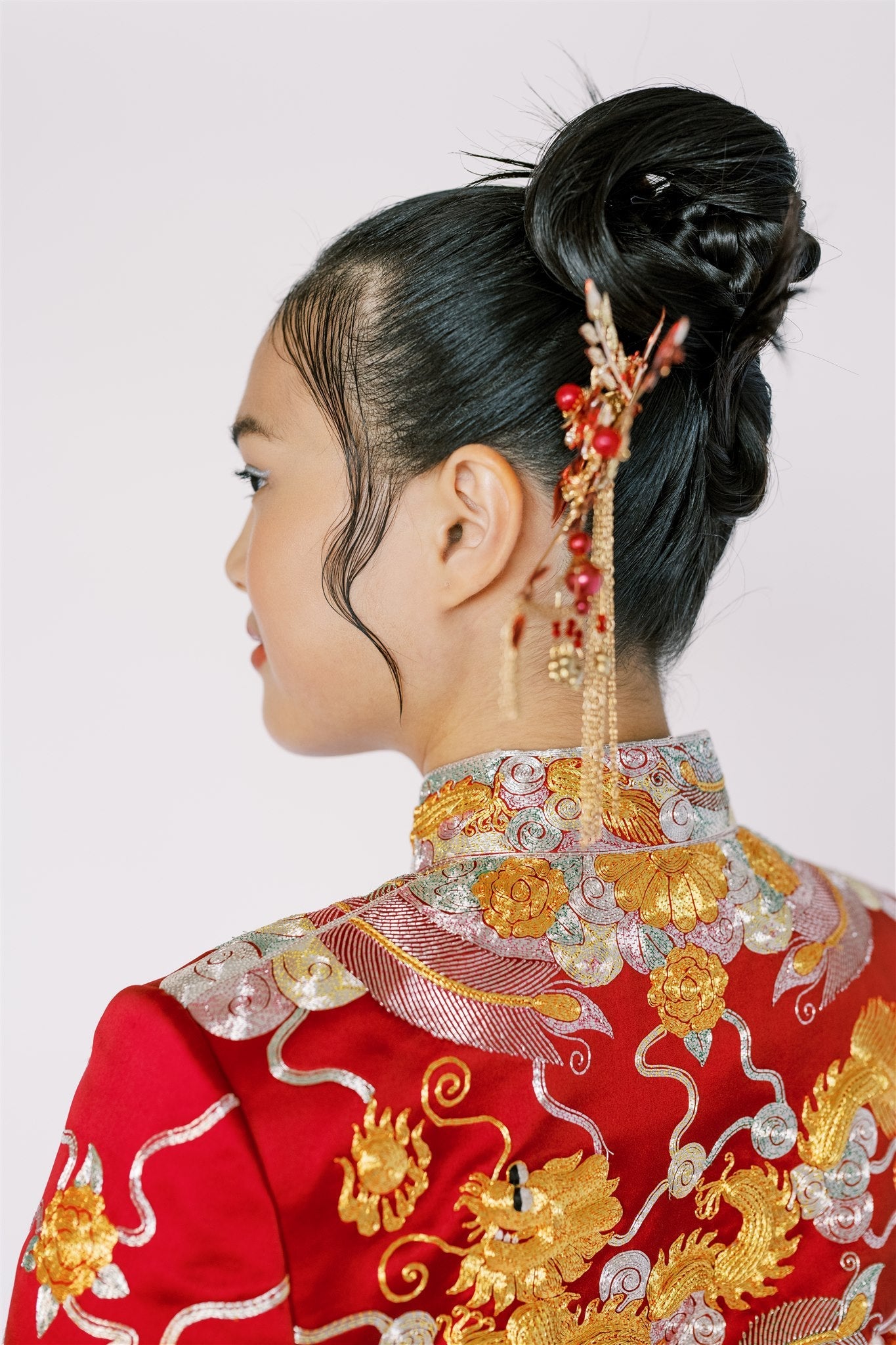 A girl wearing red Chinese Wedding Dress with peonies embroidered mandarin collar