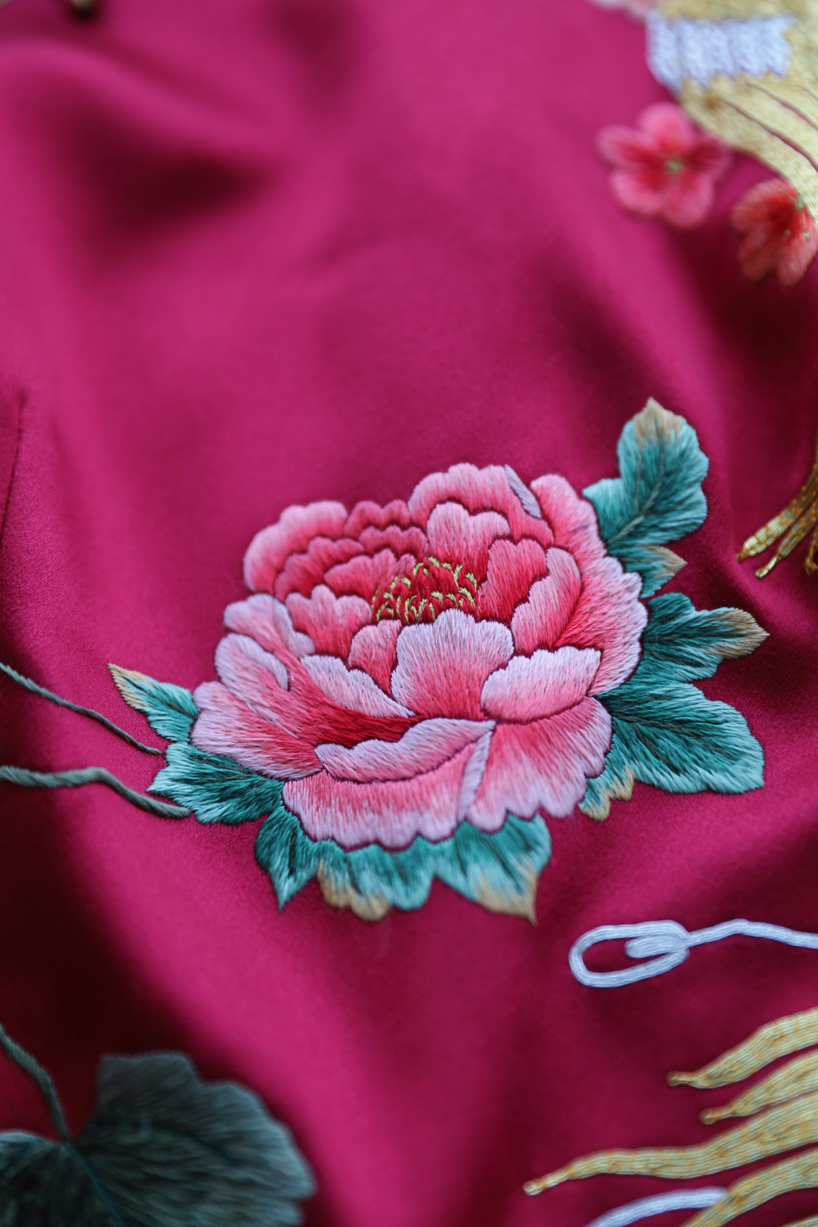 Hand embroidered peony detail on wine red silk Qipao.