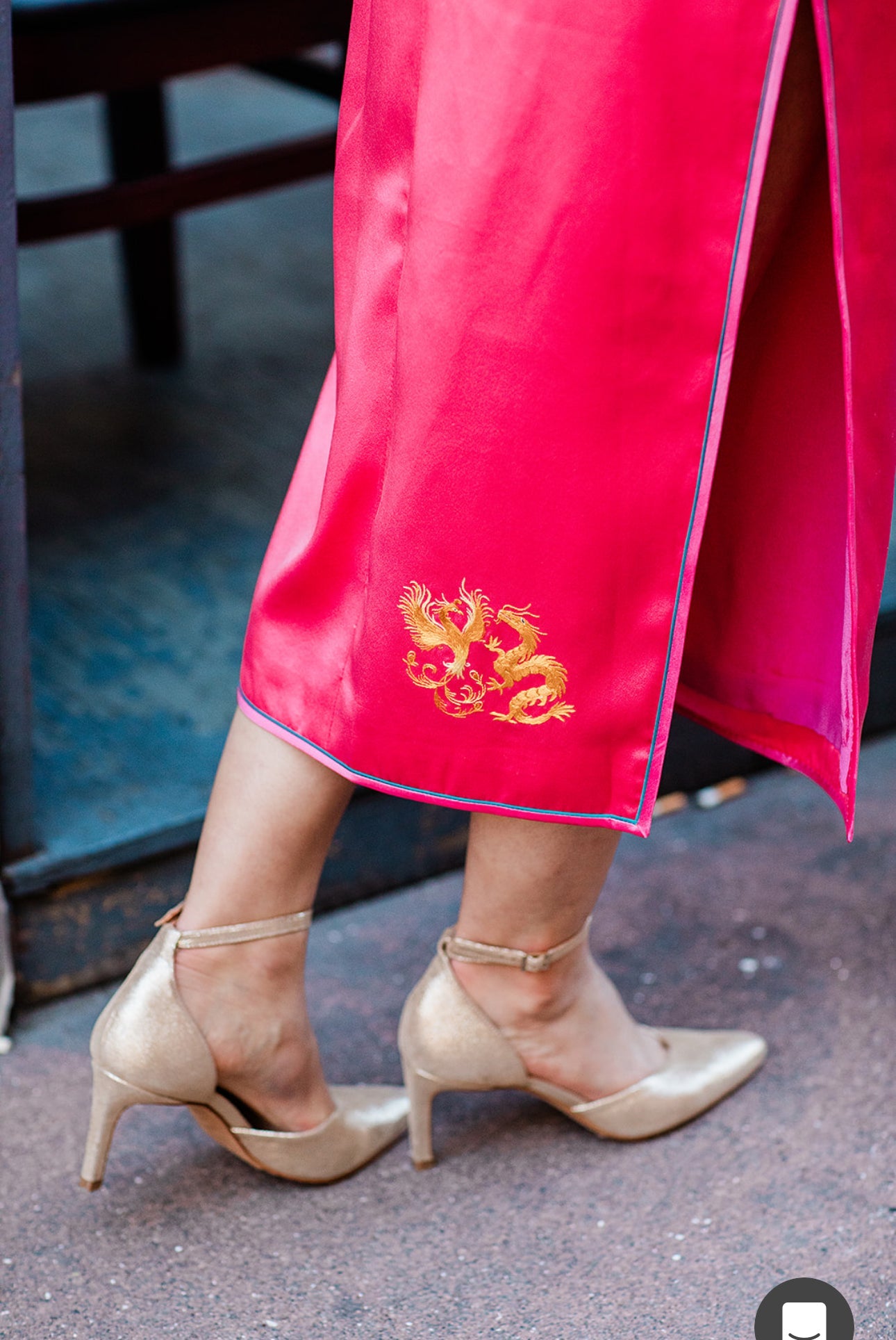 A woman wearing a red Qipao with her personalized symbol hand embroidered