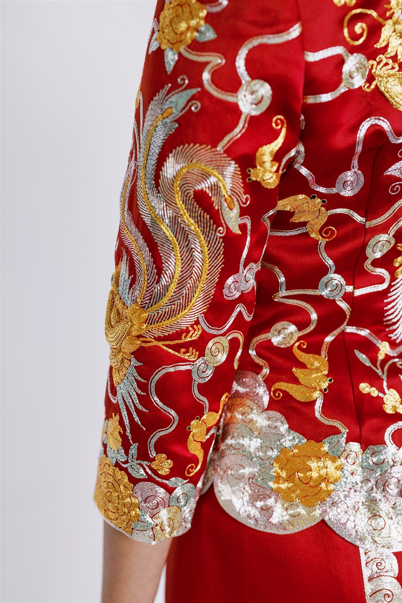 A woman wearing red traditional Chinese Tea Ceremony dress with 3/4 sleeves phoenix details