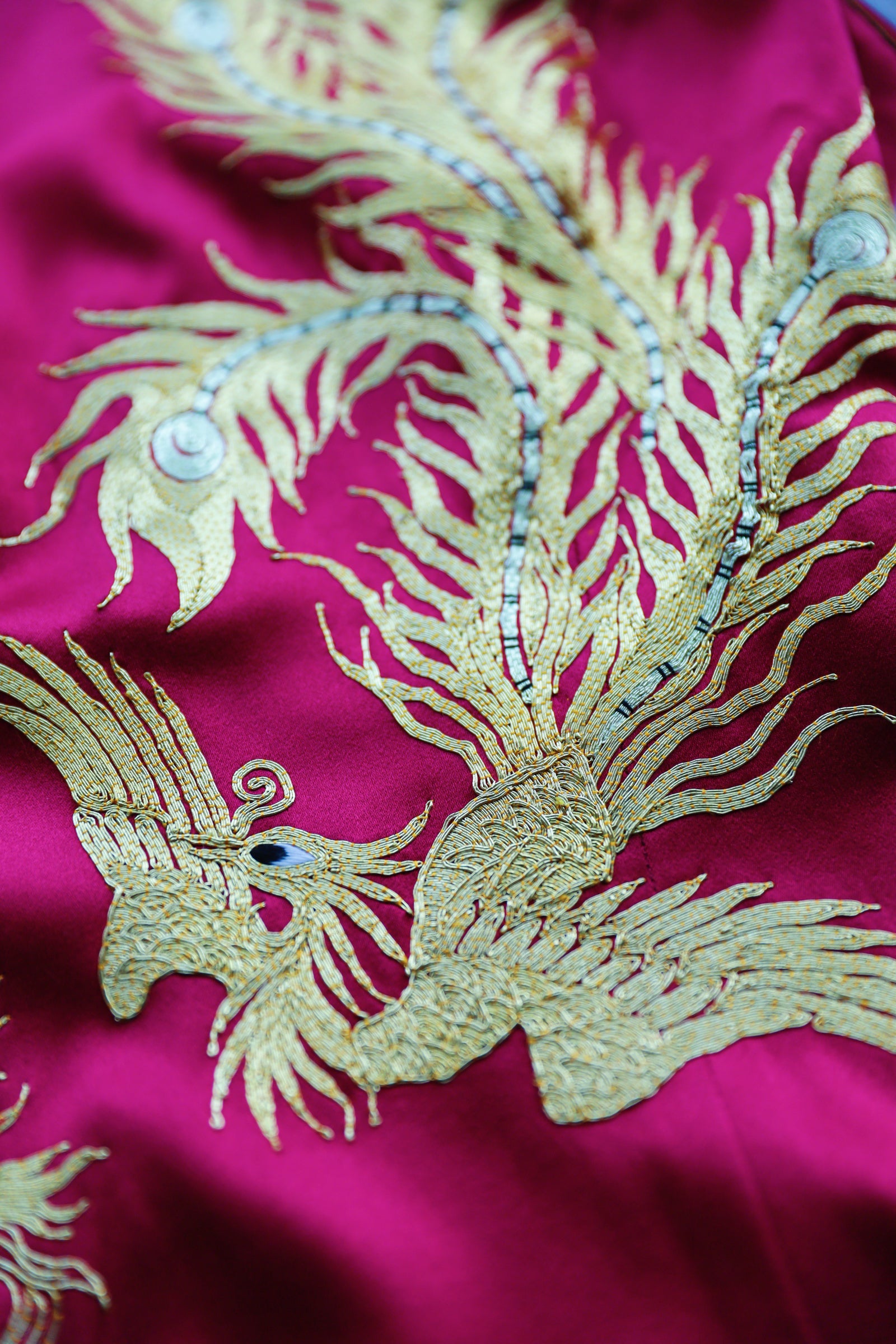Hand-embroidered phoenix detail on red silk mermaid Qipao.