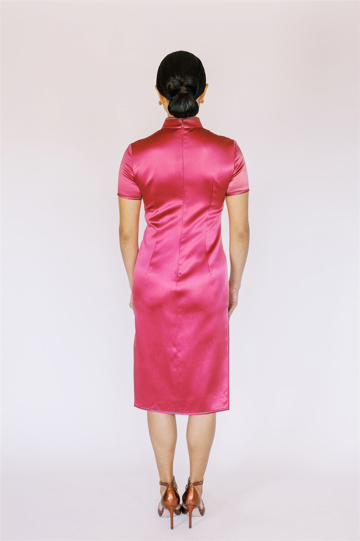 A back view of a women is wearing a pink Qipao for wedding.