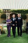 A mother wearing a beaded long Qipao and walking her son down the isle