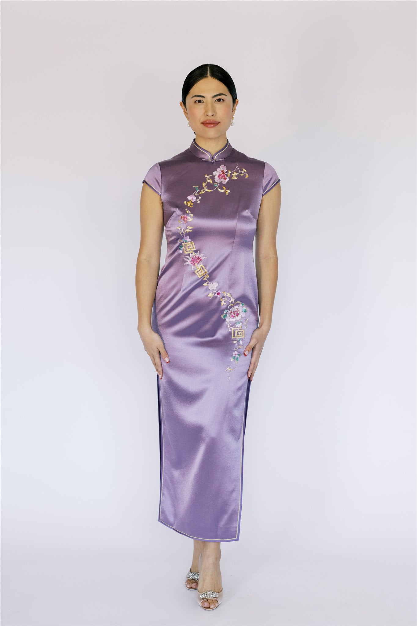 A woman wearing a purple silk traditional silk Qipao.