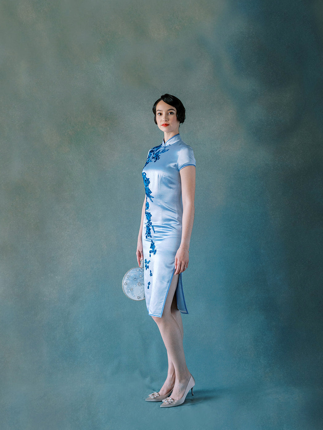 Front view of purple silk Qipao with hand-sewn velvet flower appliqué.