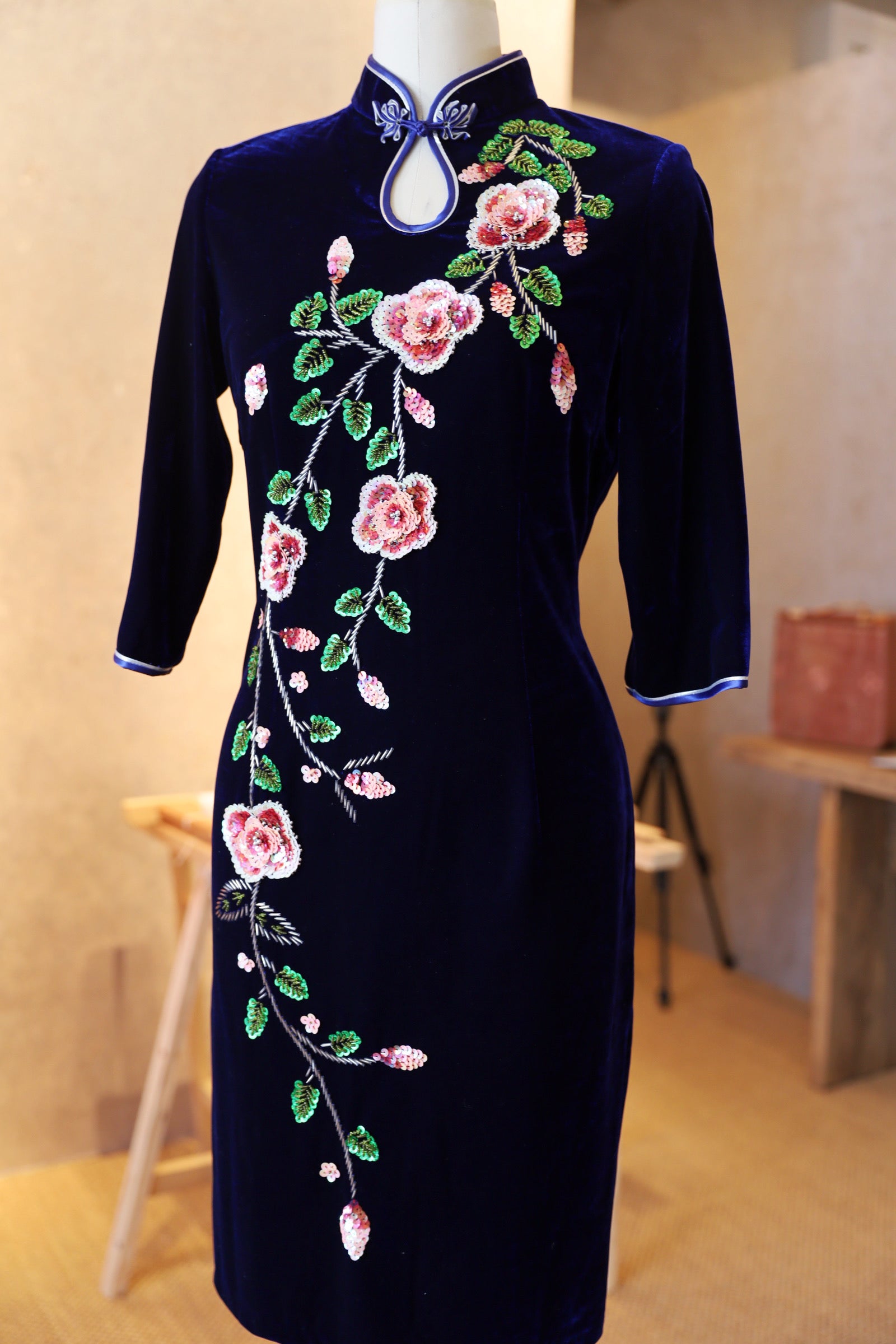 Front view of a purple velvet Qipao for mothers featuring a water drop neckline, 3/4 sleeves, and hand-beaded peonies, perfect for a Lunar New Year outfit.