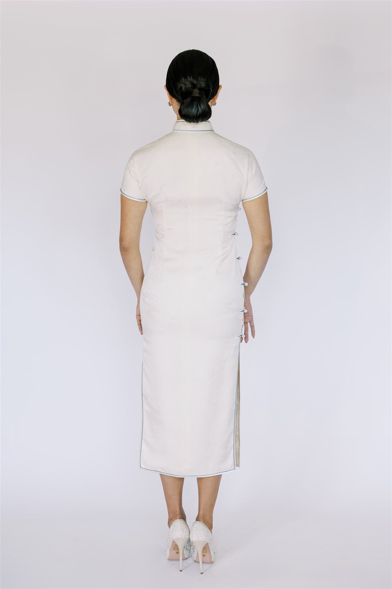 Back view of a Japanese printed silk Qipao, featuring a Mandarin collar, side cut-out, and striking blue trim for a modern design.